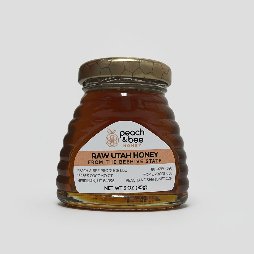 A glass beehive jar filled with raw Utah honey, labeled with the brand 'Peach & Bee' and the product name 'Raw Utah Honey'. The jar is sealed with a metal lid and placed against a pink background.
