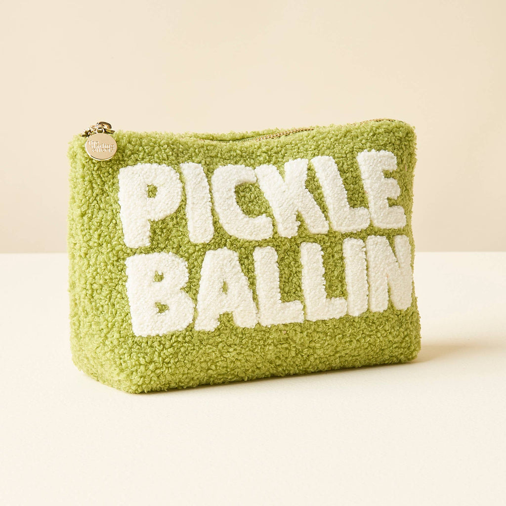 This cozy olive green teddy pouch draws inspiration from the popular sport of pickleball. With its soft, fuzzy texture and convenient zipper closure, it's perfect for storing your essentials while showcasing your love for the game. The playful pickleball-themed design adds a sporty touch to this practical accessory.
