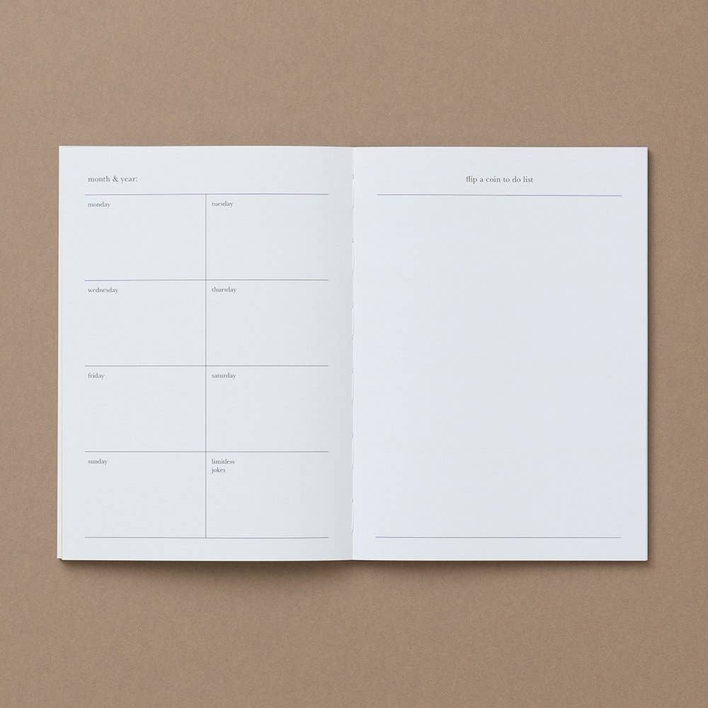 An open white planner or notebook spread with minimalist printed lines and text, placed on a warm brown kraft-paper background.
