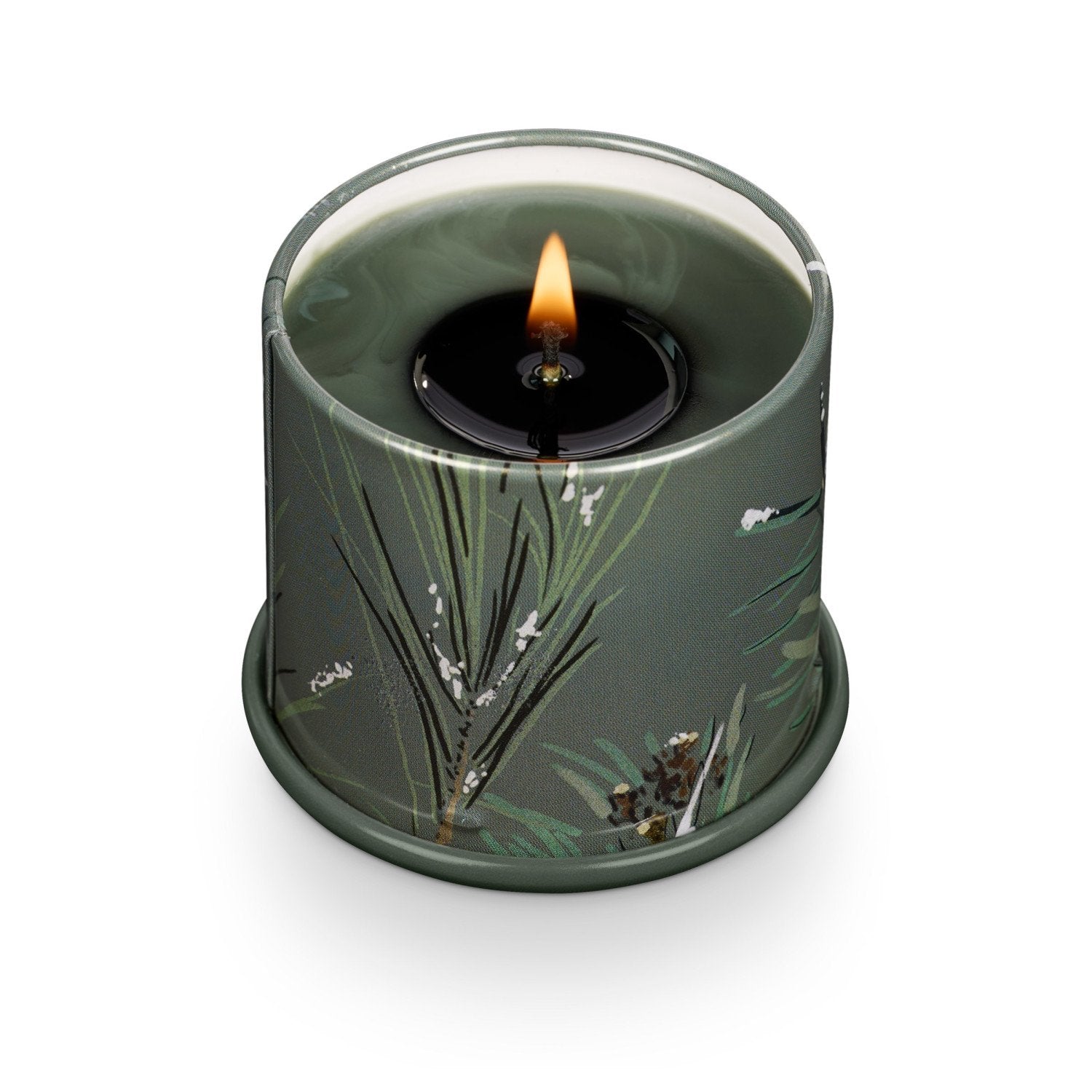 Candle in a decorative green container with natural elements on a white background