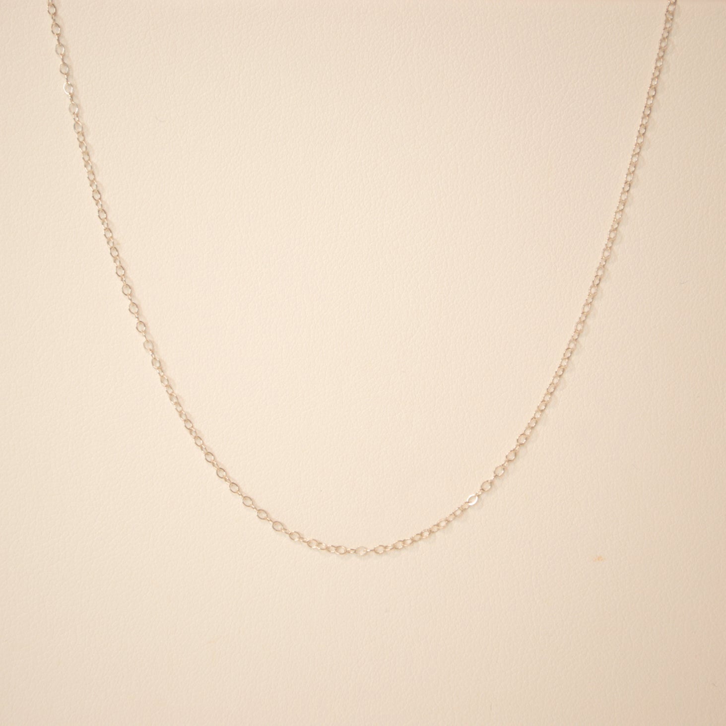 Silver chain against an off white back ground.