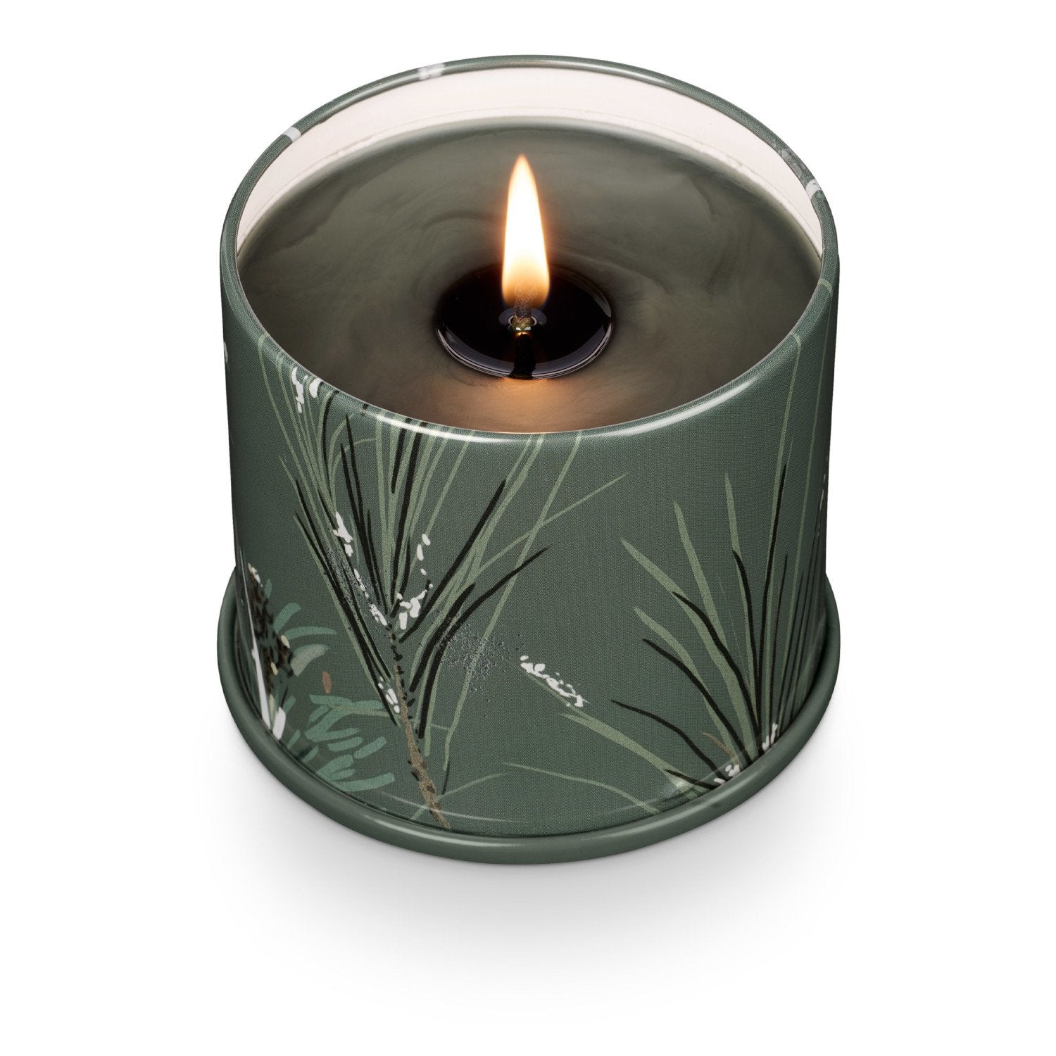 Candle in a green container with leaf pattern on a white background
