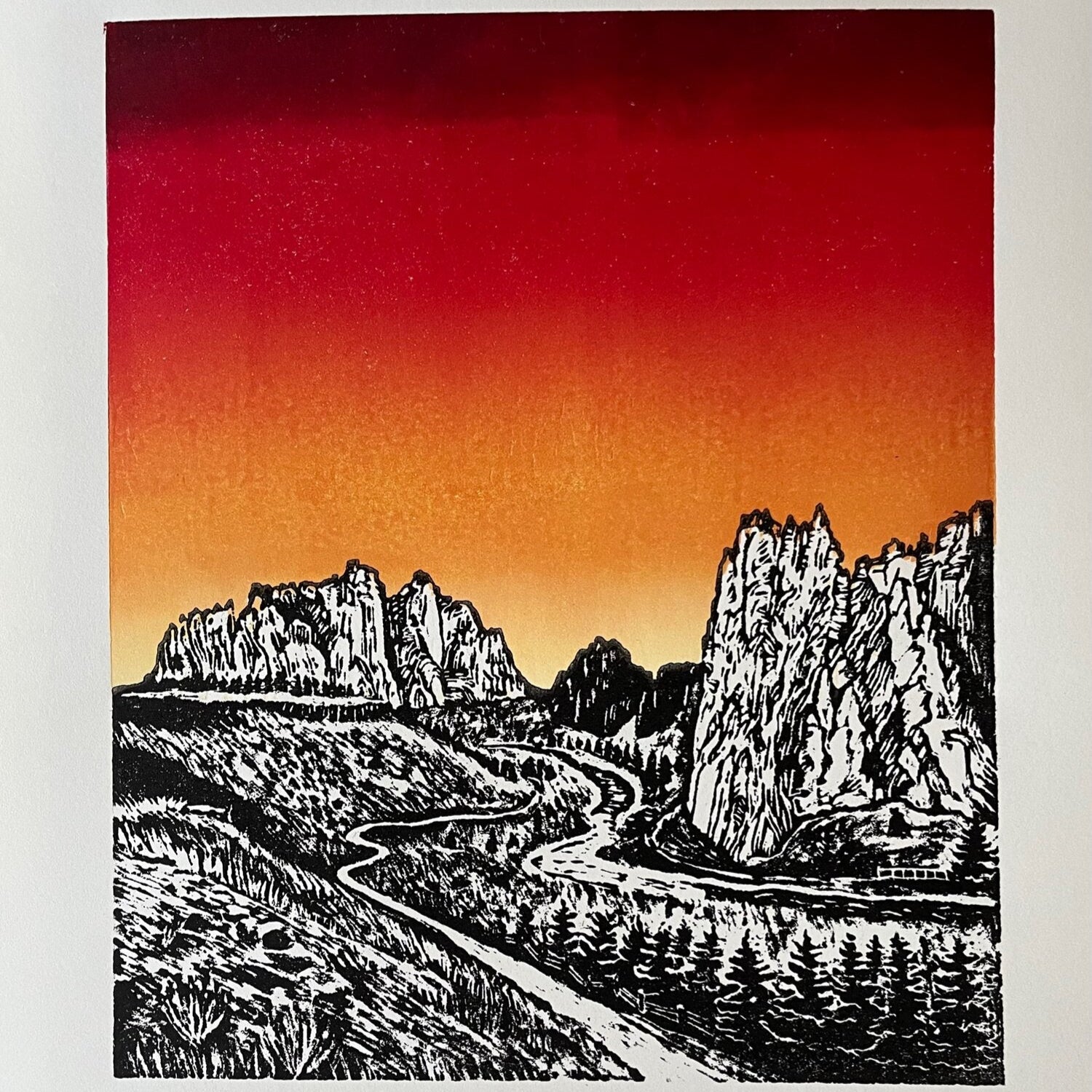 hand carved and pressed black and white 15x20 print of Smith Rock with a red and orange sunset