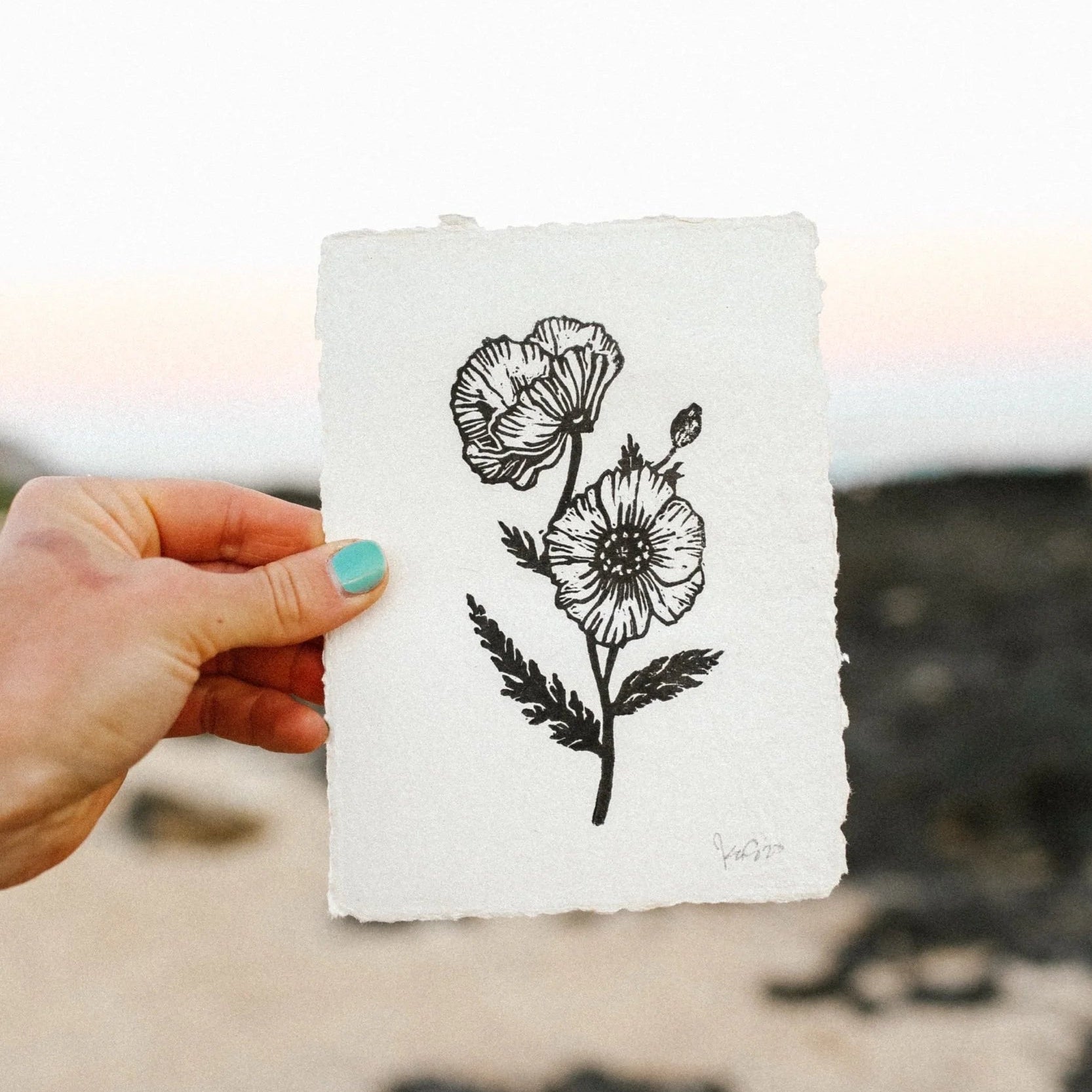 A relief linocut print of poppies on paper torn on all the edges. 