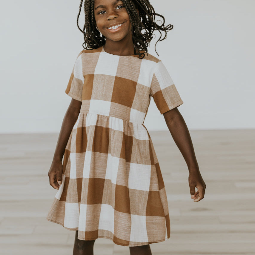 Now you and your mini can match in this ROOLEE classic! This dress features a timeless buffalo plaid that is bold, sophisticated and the perfect style for every occasion. Breathable, woven material is paired with hip pockets, half sleeves, a full lining, a gathered waist, and a flowing skirt. The Mini Maddie Buffalo Plaid Dress is adorable, versatile, and sure to be your daughter's favorite dress! Peru Plaid
