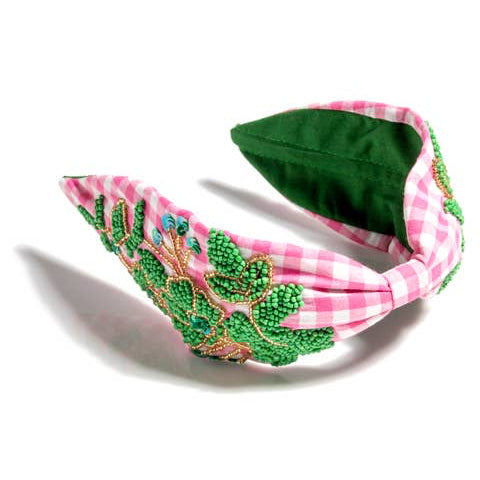 Elevate your look with our Embellished Check Wide Headband, crafted from quality polyester and handmade in India. This traditional gingham check headband features delicate hand beading details for a touch of elegance. Choose between two beautiful color options: green or pink. A comfortable and stylish accessory to complete any outfit.