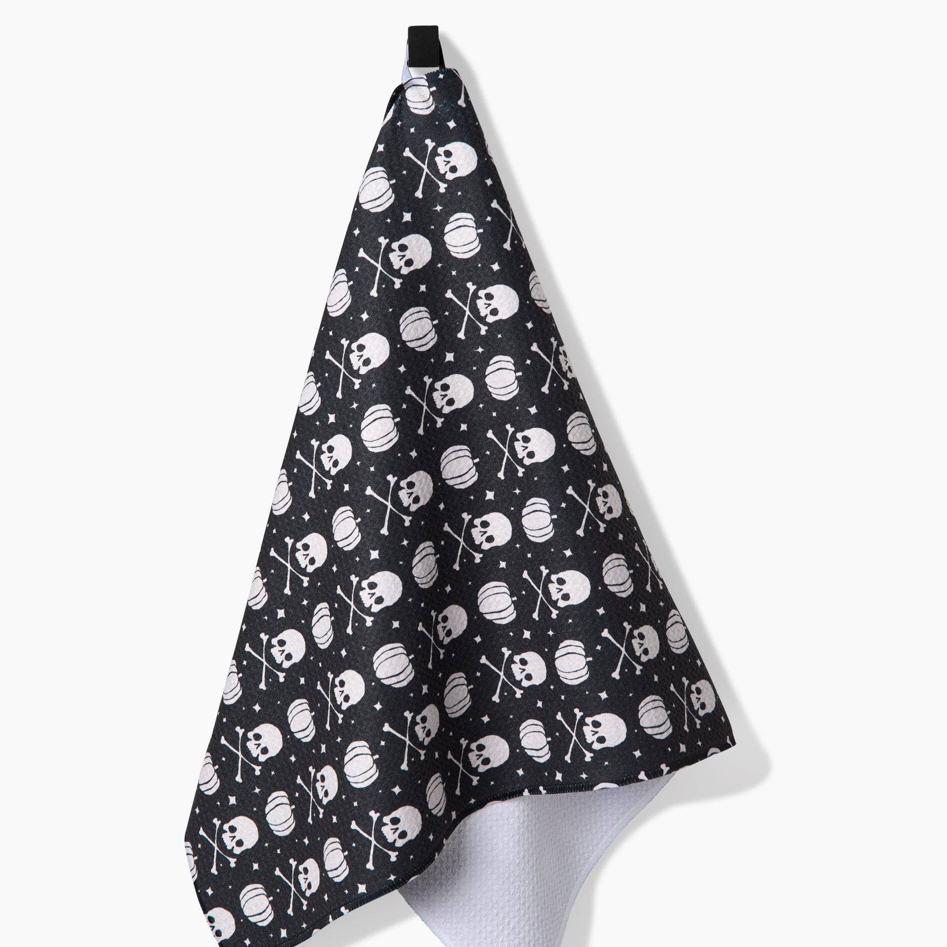 Black towel with pumpkins and white skull and crossbones pattern on a white background