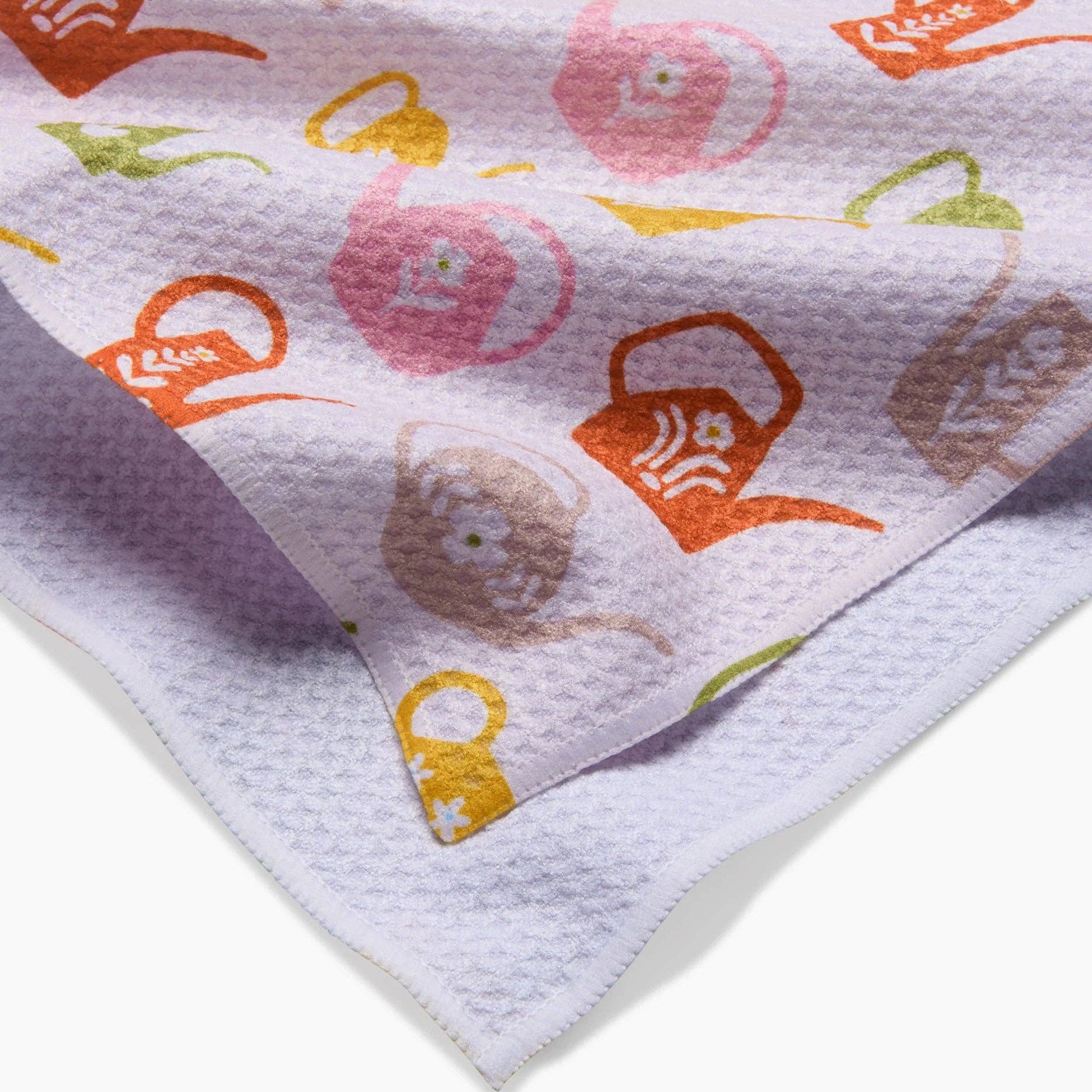 Patterned fabric with colorful watering cans and flowers on a white background