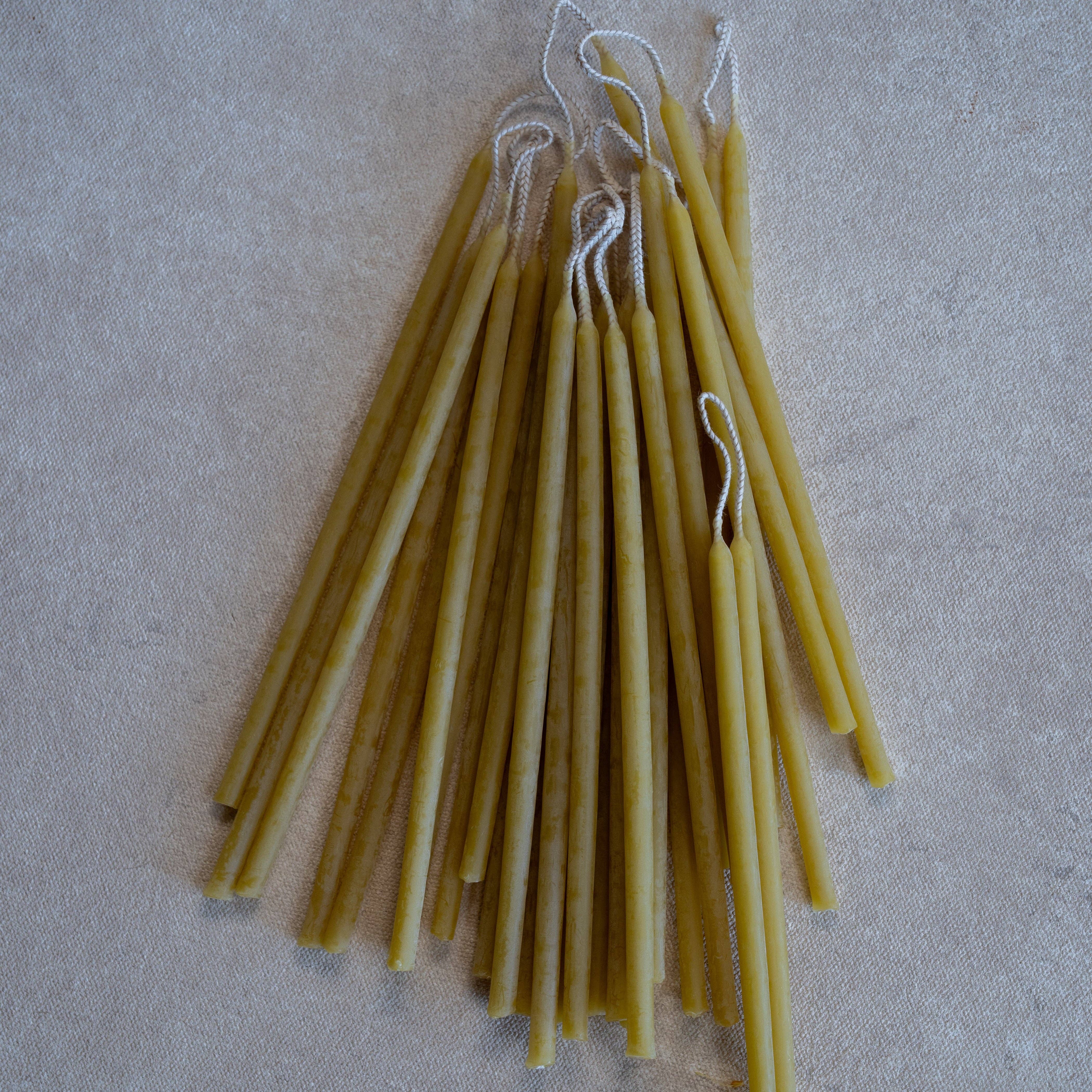 Olive color candles on a textured beige surface