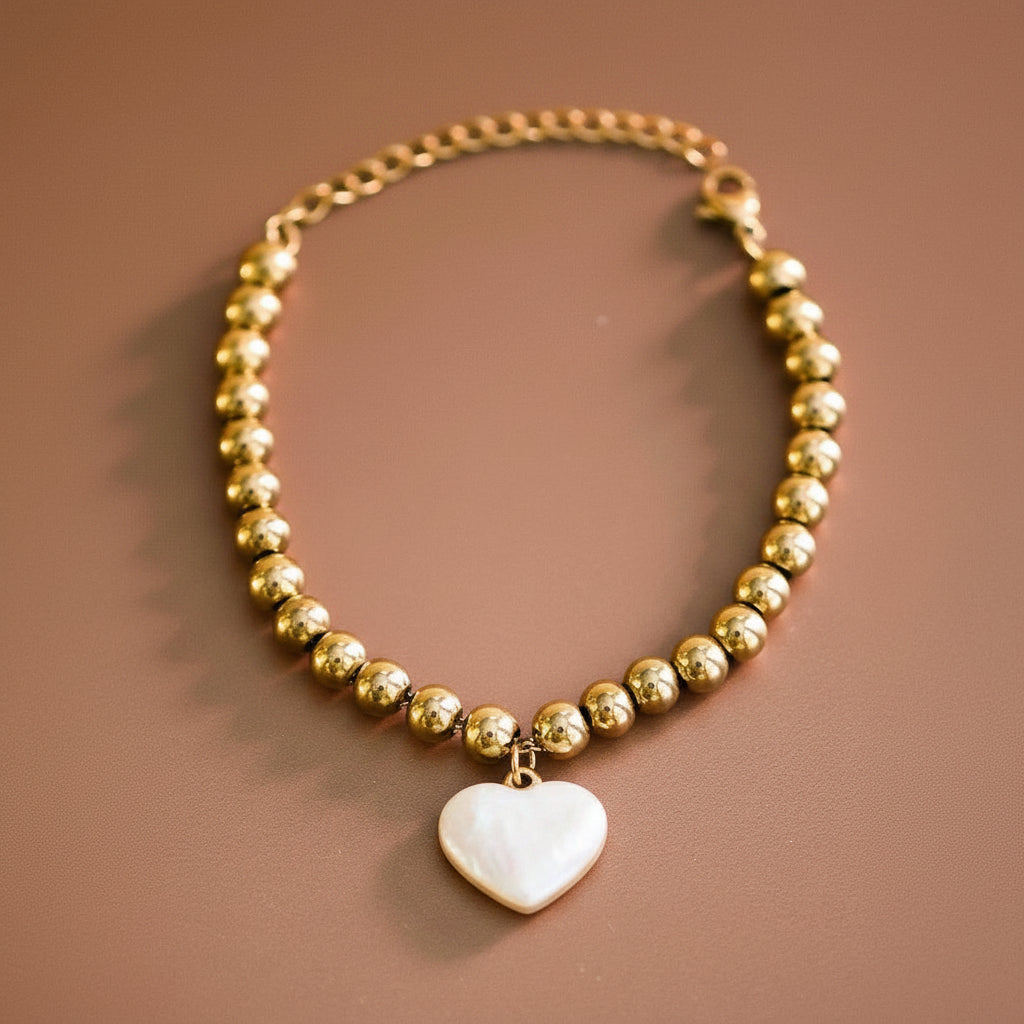Elevate your everyday style with this 18K gold plated stainless steel beaded chain bracelet, featuring a delicate heart charm. Crafted from hypoallergenic materials, it's perfect for sensitive skin. The waterproof and tarnish-resistant design ensures lasting brilliance, making it ideal for daily wear. To maintain its radiant finish, avoid prolonged contact with lotions, perfumes, and cleaning products. A versatile accessory that combines elegance with durability.