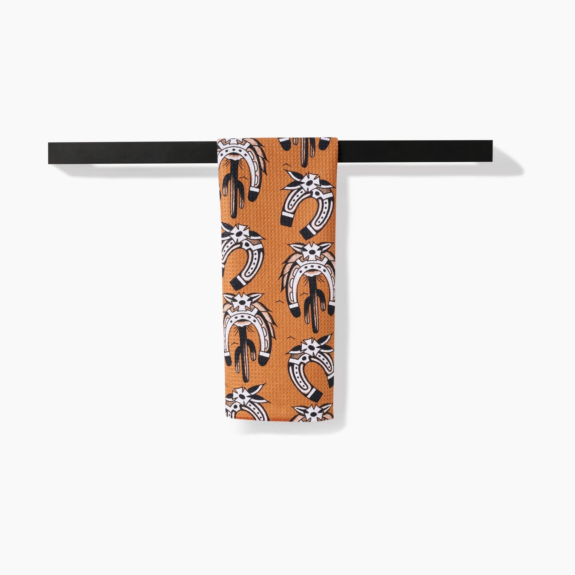 Patterned towel hanging on a black rod against a white background
