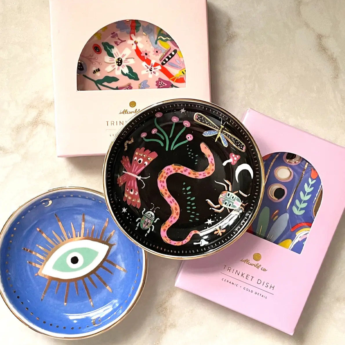 Set of decorative trinket dishes with artistic designs on a marble surface.