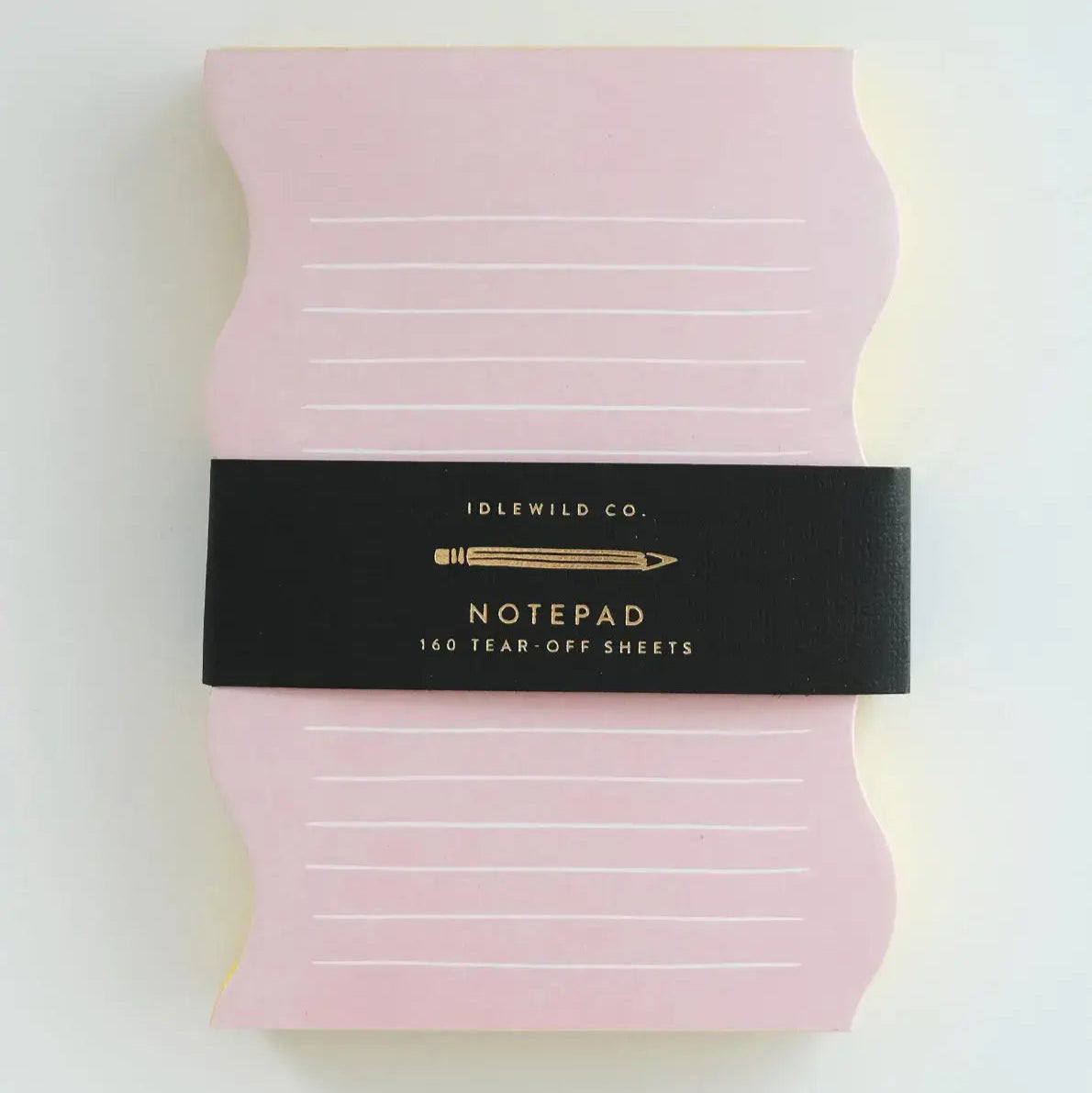 Pink notepad with a black band labeled 'Idlewild Co. Notepad' on a white background