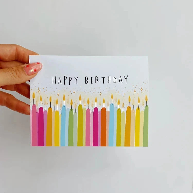 White card reading "happy birthday" with candles along the bottom