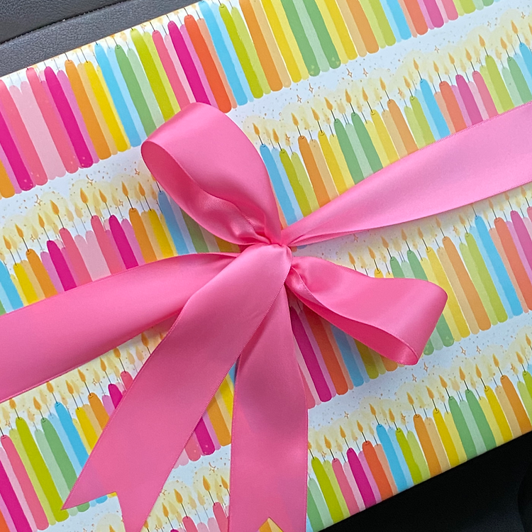 white wrapping paper with an assortment of colorful birthday candles