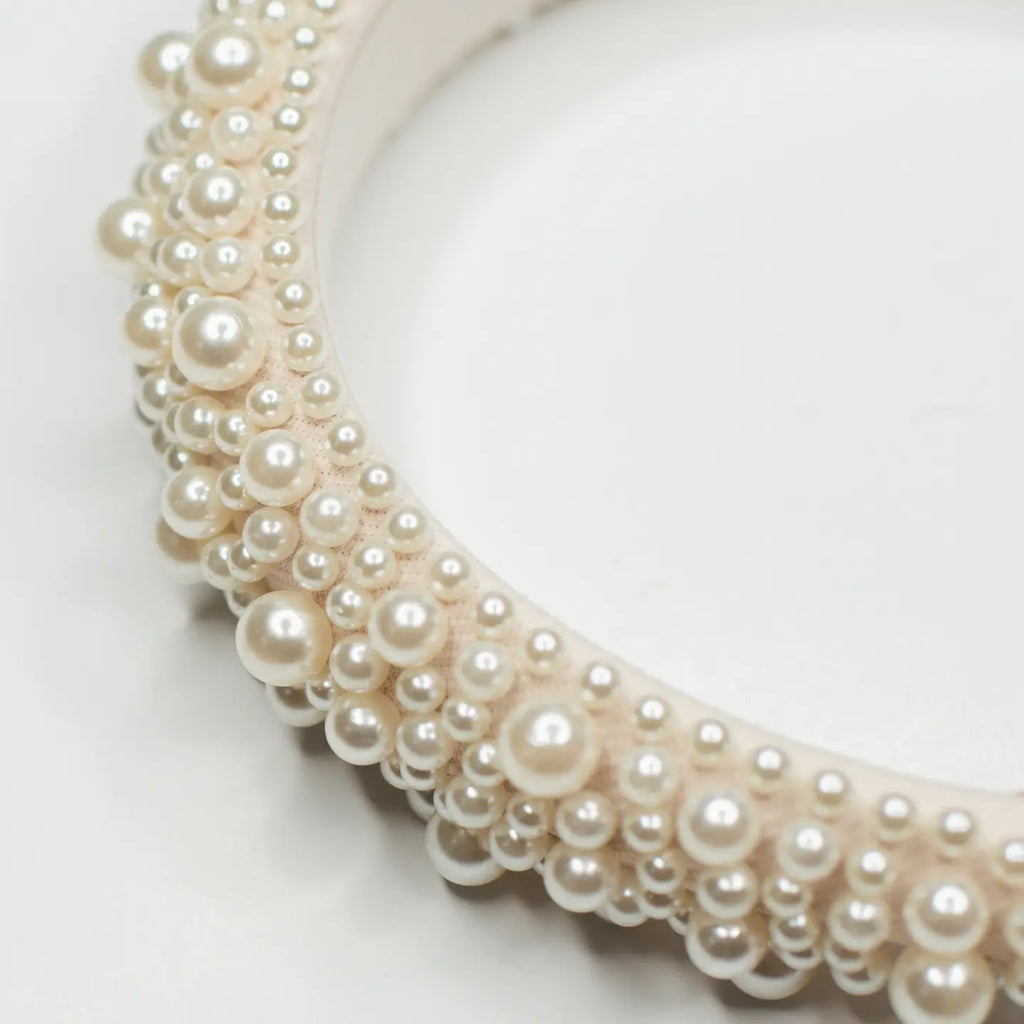 Add a touch of glamour to your look with our stunning pearled headband, meticulously hand-crafted with a range of different-sized pearls that exude a touch of classy elegance. We wanted to bring a new line of high-quality hair accessories to bring a luxury feeling to your customers. Whether dressing up for a special occasion or adding a chic accent to your everyday style, this headband is the perfect choice. Indulge yourself with this stunning headband that we adore so much.