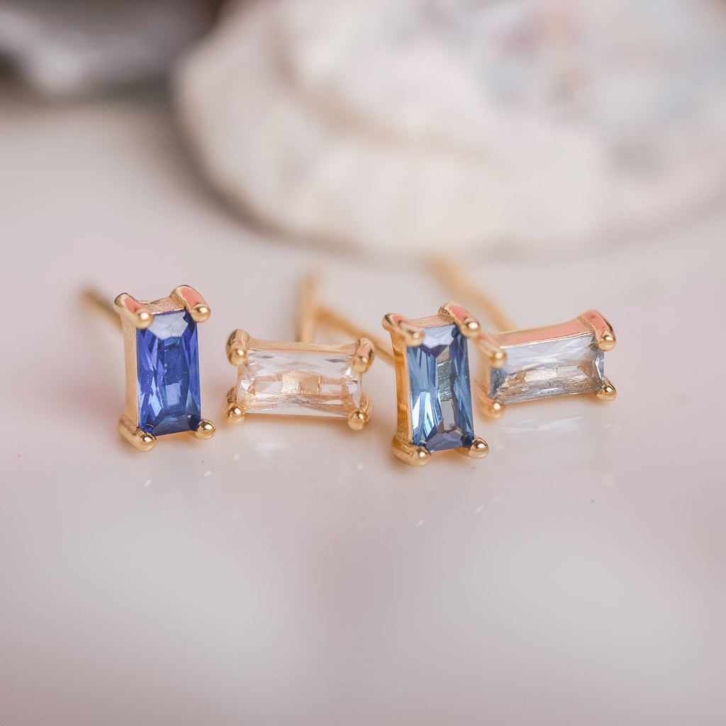  Birthstone Ombre Baguette Stud Earring Set, a collection of four stunning earrings crafted in 18k gold plated with an anti-tarnish coating. This set of stud earrings showcases the ombre effect, seamlessly blending hues from light to dark, creating a captivating visual representation of your birthstone's color spectrum. 