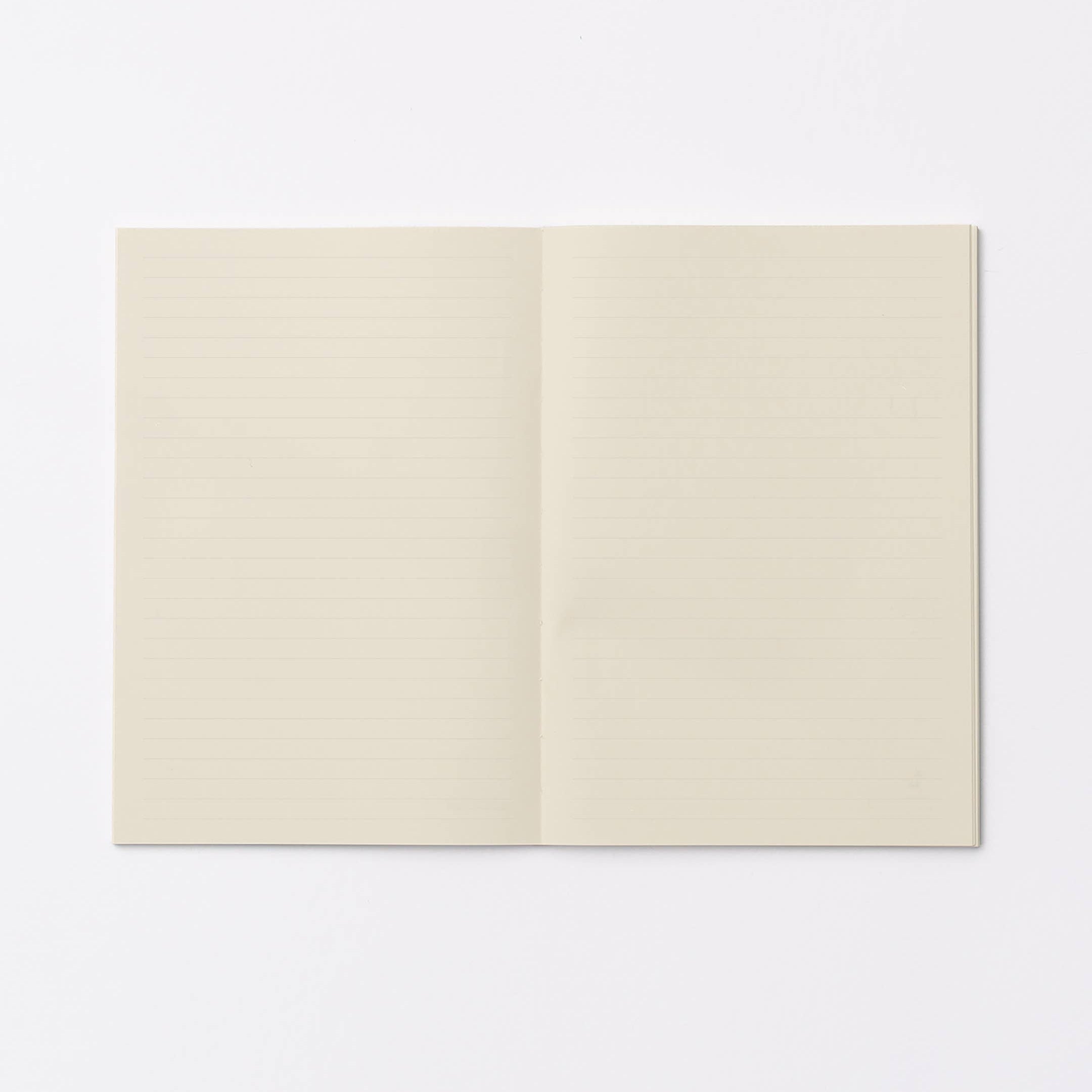 An open notebook with cream-colored, lined pages, displayed flat against a clean white background.
