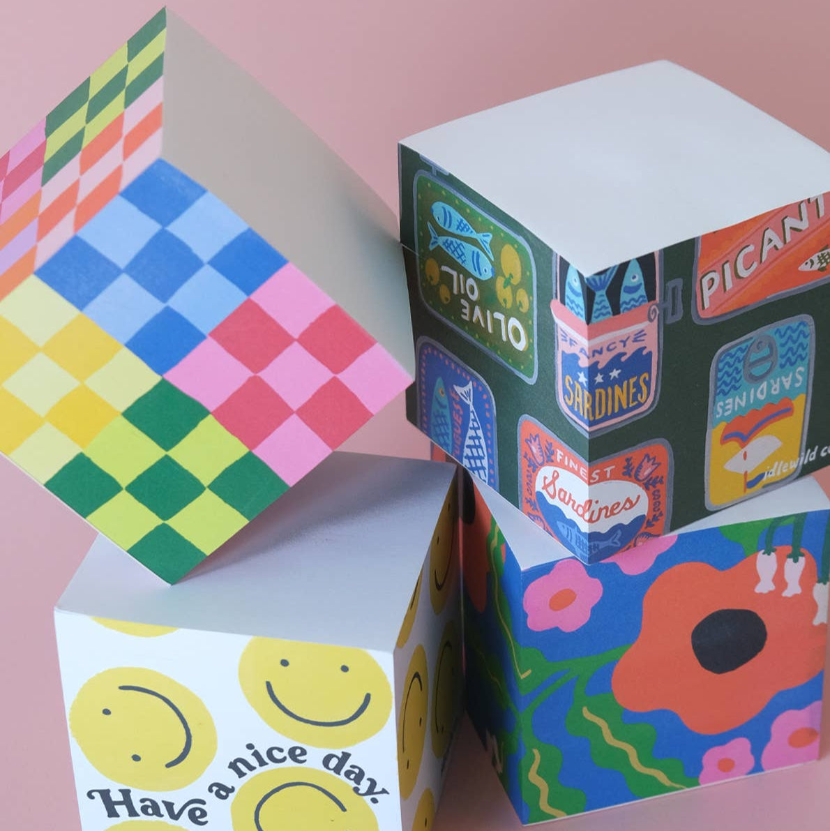 Colorful paper boxes with various designs on a pink background
