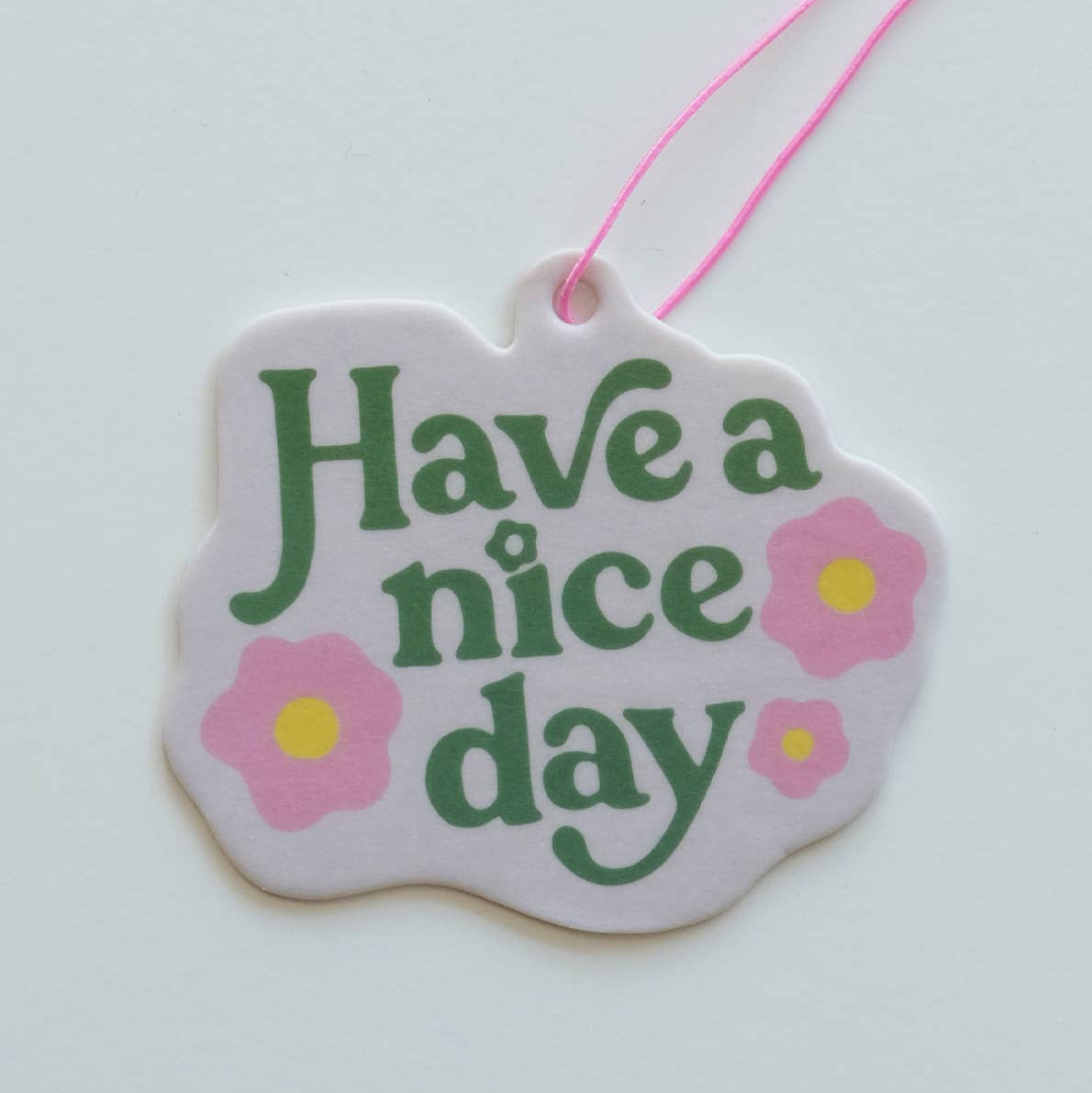 Decorative air freshener with 'Have a nice day' text and flowers on a white background