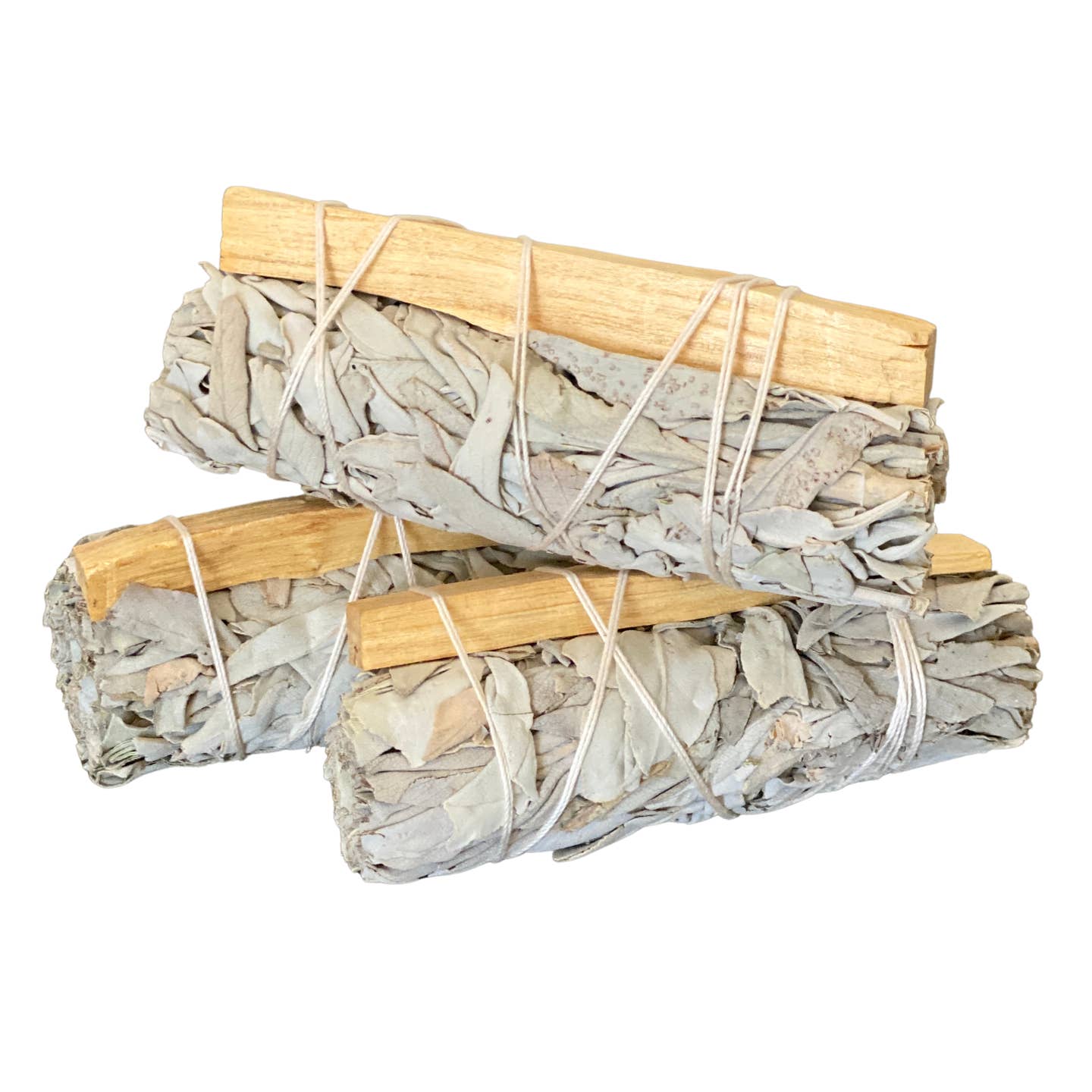 Three bundles of sage wrapped in wood and twine on a white background