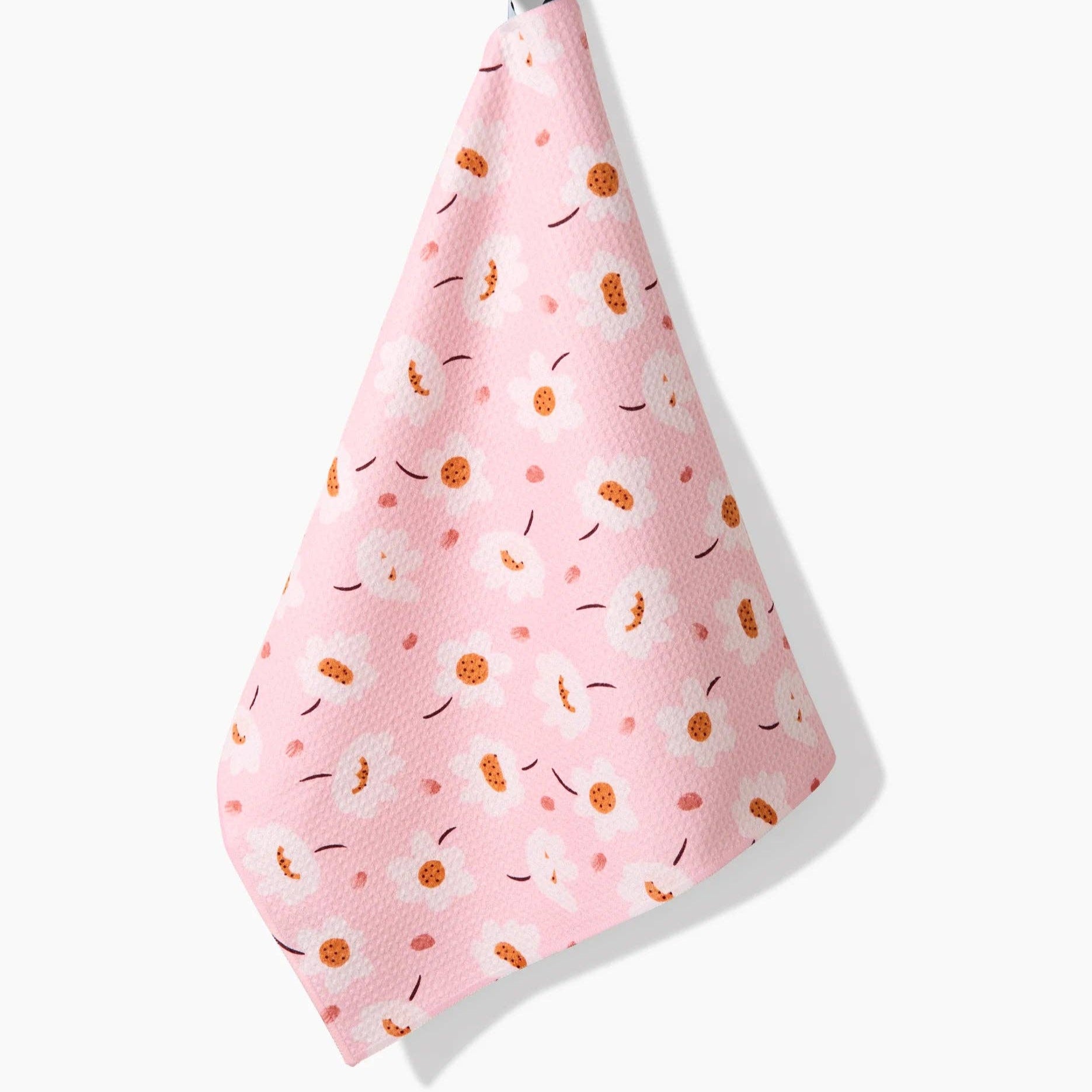 Pink towel with orange and black pattern hanging on a white background