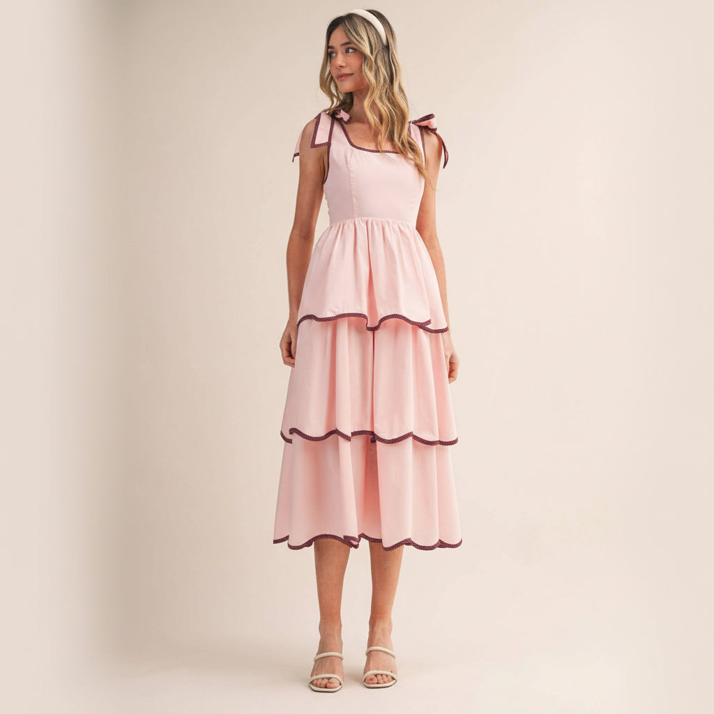This charming contrast binding tiered midi dress celebrates your unique style with thoughtful details designed to make you feel confident and beautiful. The square neckline and tying straps feature elegant contrast binding that frames your shoulders perfectly, while the fitted bodice with smocked elastic back provides comfortable support throughout your day. Layers of tiered skirt create graceful movement and dimension, each adorned with contrast binding for a polished, intentional look.