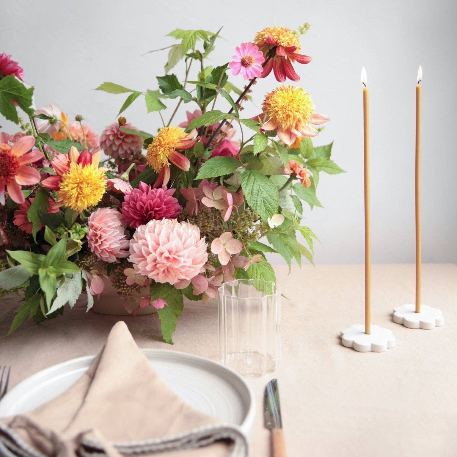 Floral arrangement on a table with candles and cutlery
