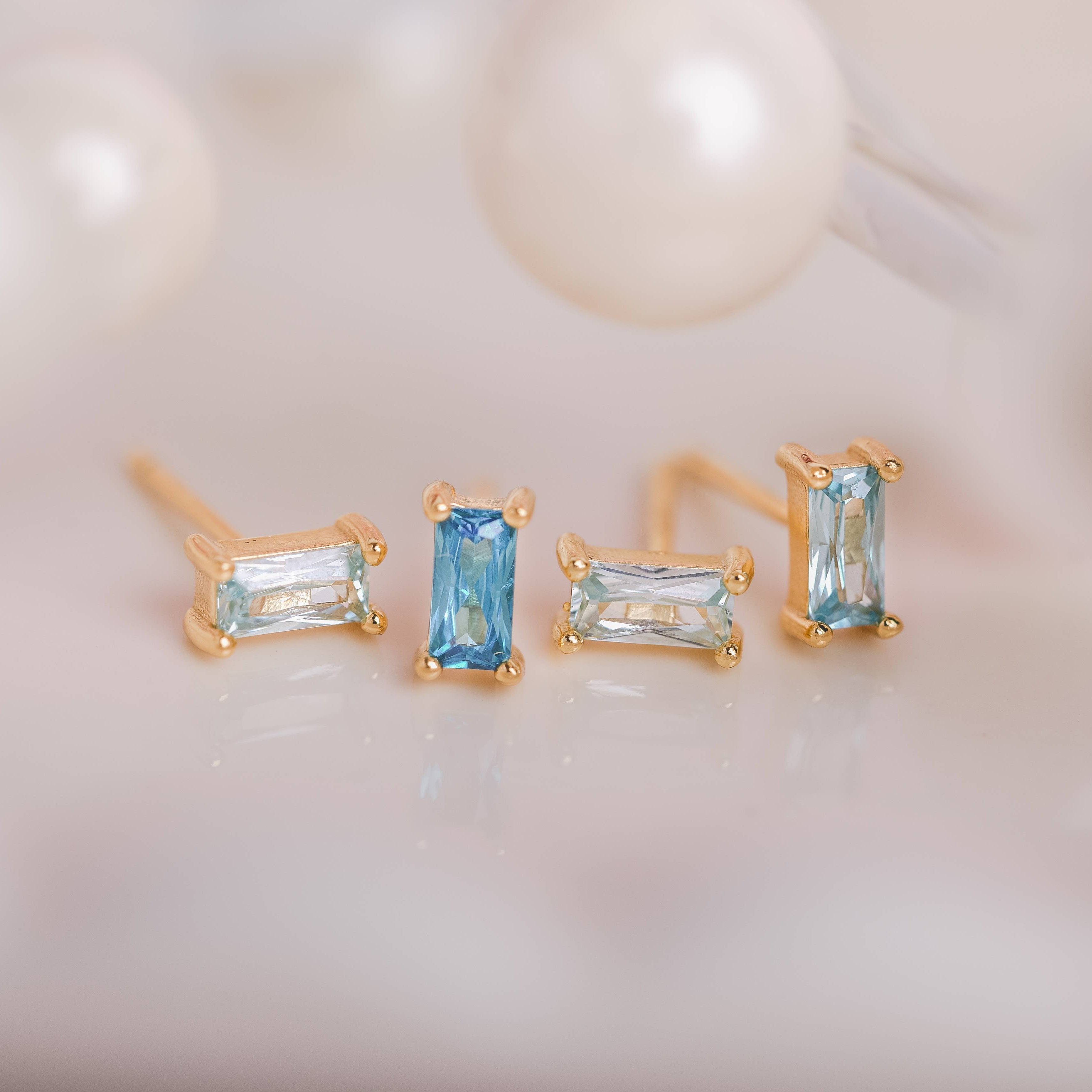  Birthstone Ombre Baguette Stud Earring Set, a collection of four stunning earrings crafted in 18k gold plated with an anti-tarnish coating. This set of stud earrings showcases the ombre effect, seamlessly blending hues from light to dark, creating a captivating visual representation of your birthstone's color spectrum. 