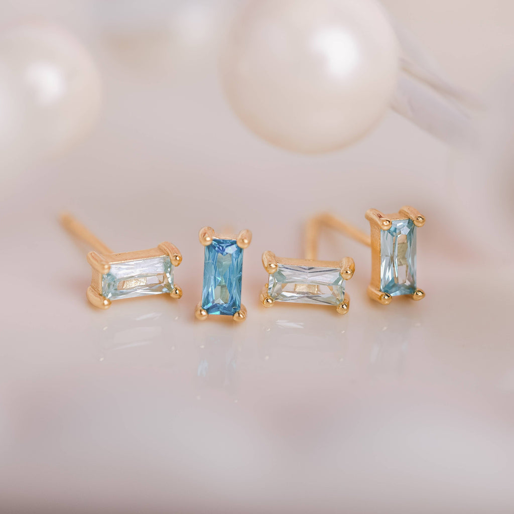  Birthstone Ombre Baguette Stud Earring Set, a collection of four stunning earrings crafted in 18k gold plated with an anti-tarnish coating. This set of stud earrings showcases the ombre effect, seamlessly blending hues from light to dark, creating a captivating visual representation of your birthstone's color spectrum. 