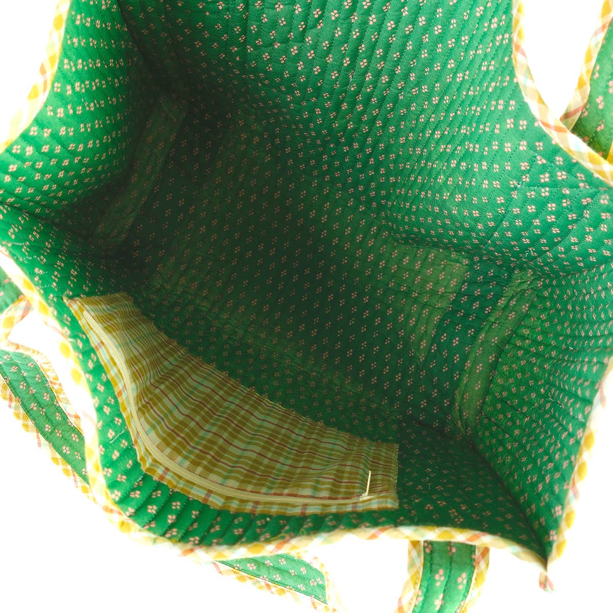 Close-up of a green fabric with yellow patterns on a white background