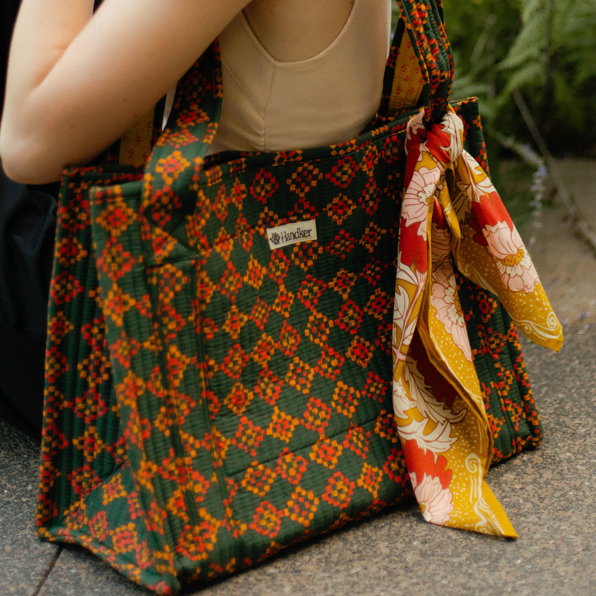 Patterned tote bag with visible brand logo on a textured surface