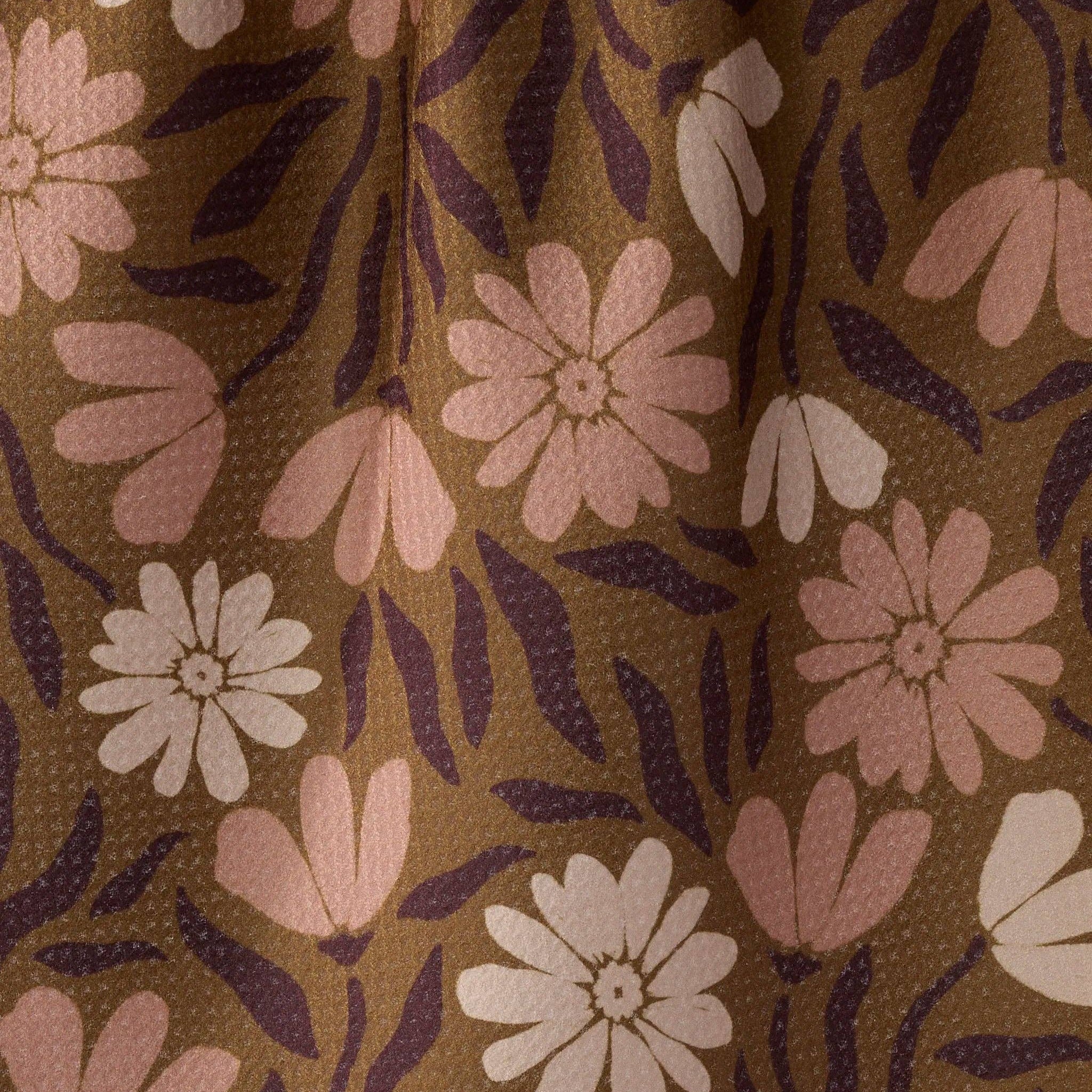A close-up of a fTEA TOWEL  pattern featuring stylized pink and off-white flowers with dark purple leaves on a warm brown background.