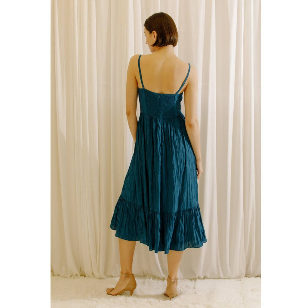 Monochromatic blue crepe textured bustier midi dress. It shows a sweetheart neckline, empire-fitted waist, and sheer fabric but underlined. It also has a smocked upper back, back zipper, and ruffled hem.
