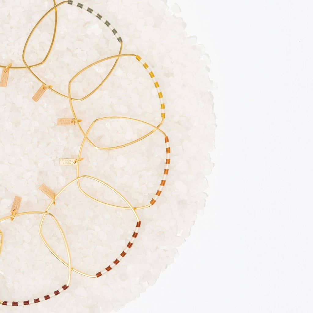 You'll be smitten with the Checkerboard Bangle. The soft cotton fibers hopscotch playfully between the vintage-inspired colorways and the classic natural hue to create a statement that will add the finishing touch to your artful look. Sage / Gold color.
