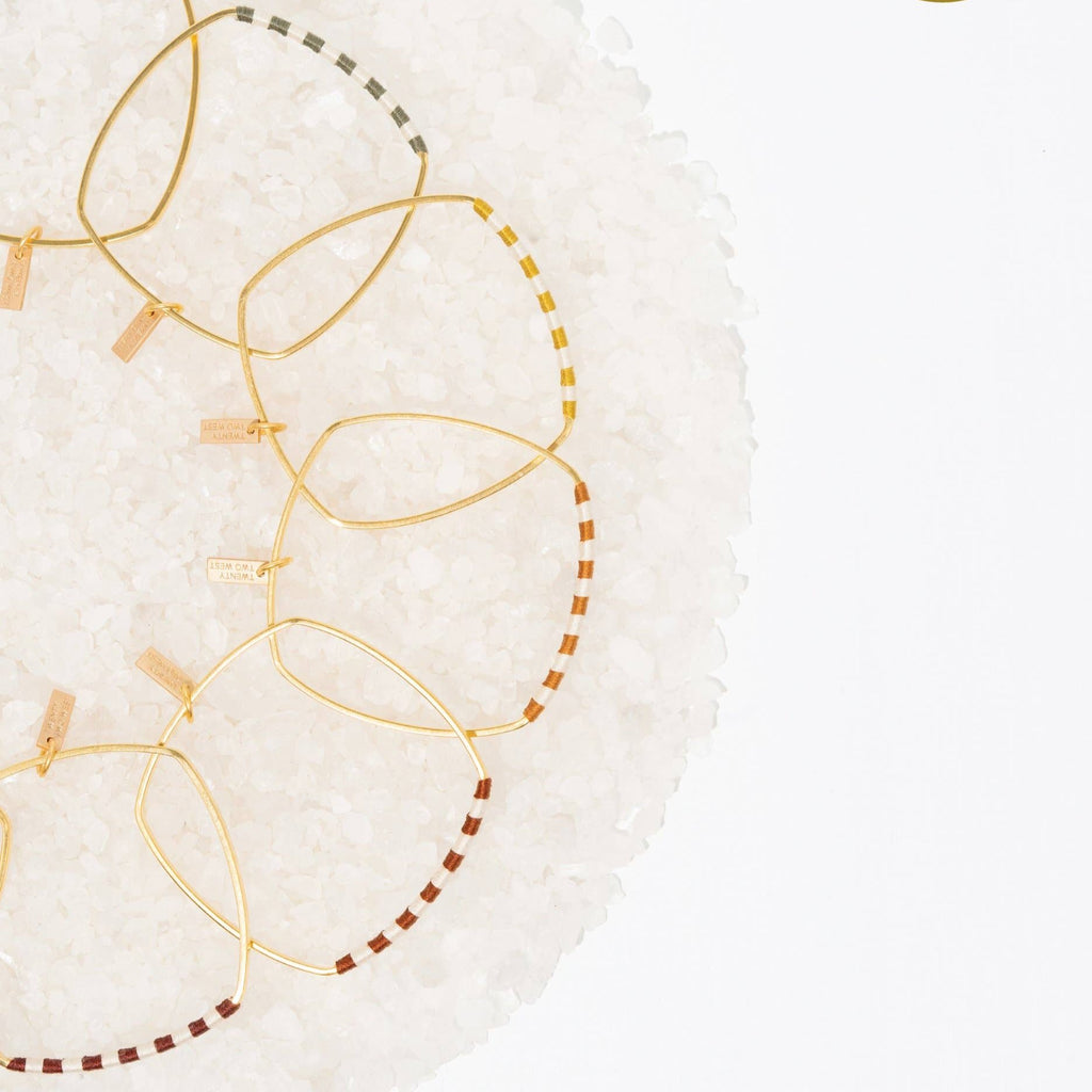You'll be smitten with the Checkerboard Bangle. The soft cotton fibers hopscotch playfully between the vintage-inspired colorways and the classic natural hue to create a statement that will add the finishing touch to your artful look. Chamomile / Gold color.