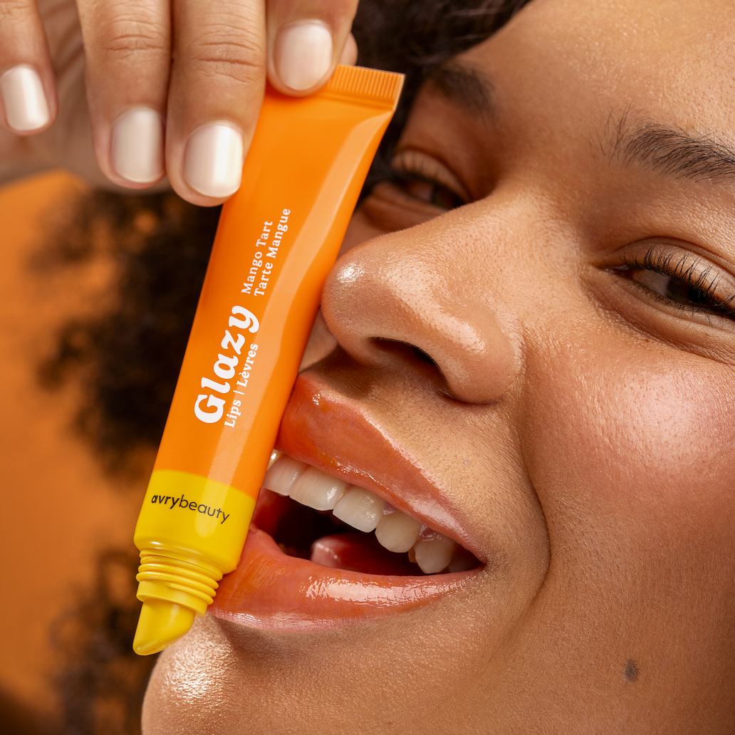Person holding an orange Glazy product near their face