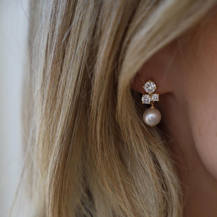 The Dahlia Studs are a beautiful addition to any bridal look or event that you may have coming up. Featuring a cubic zirconia cluster stud with a drop pearl, you can't go wrong with this elegant piece!