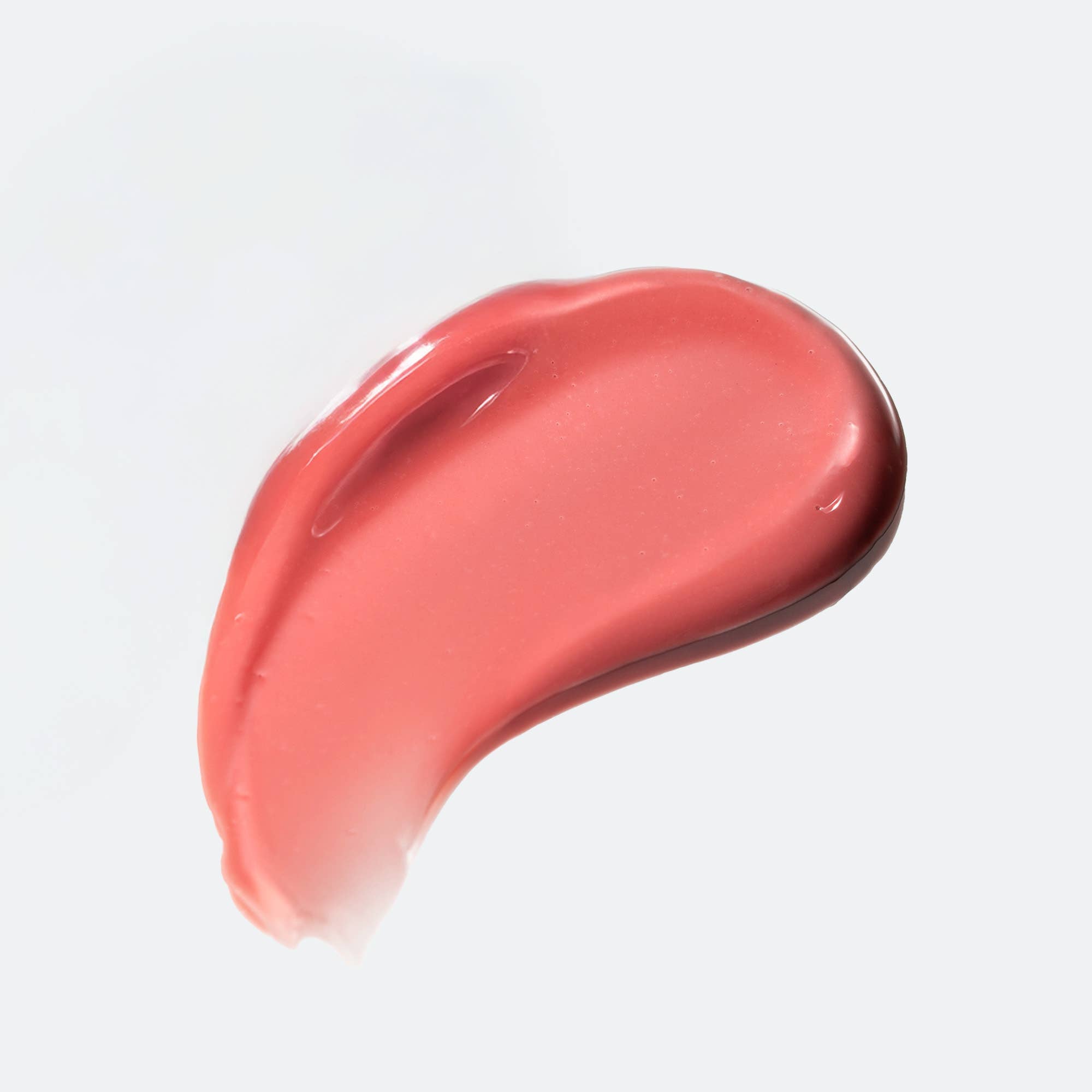 Pink lip balm smear on a light gray background