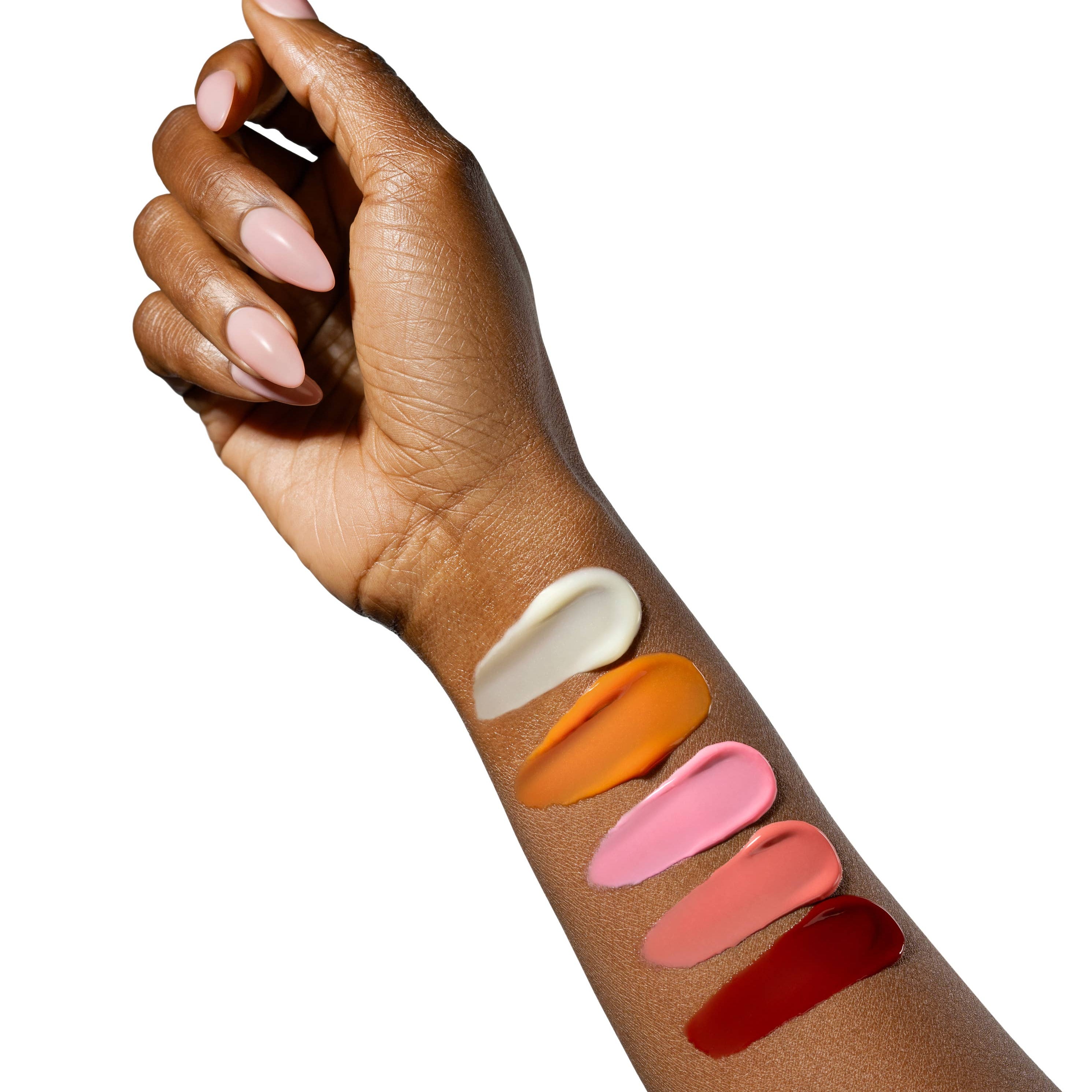 Hand with swatches of different lip colors on a white background