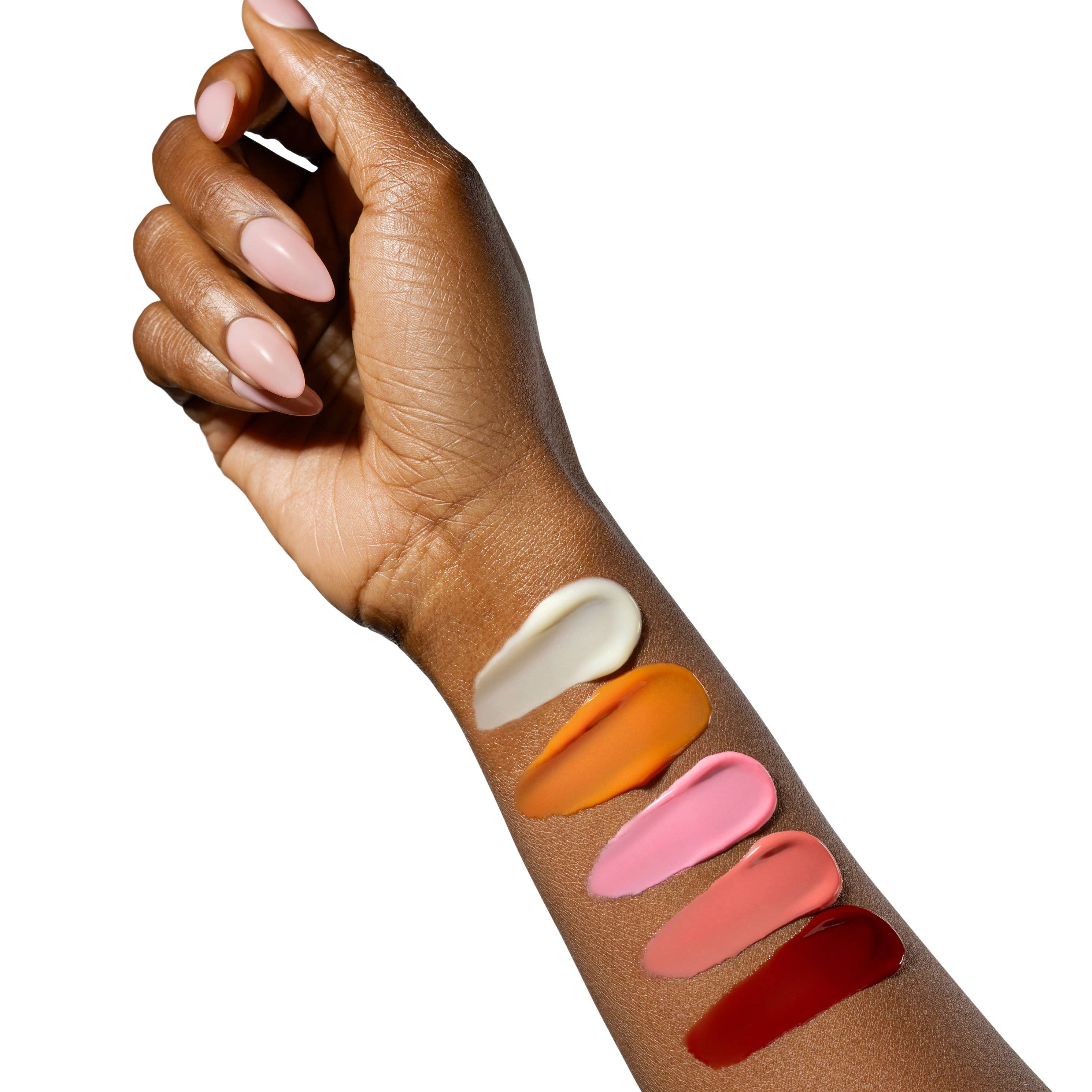 Hand with swatches of different lip colors on a white background