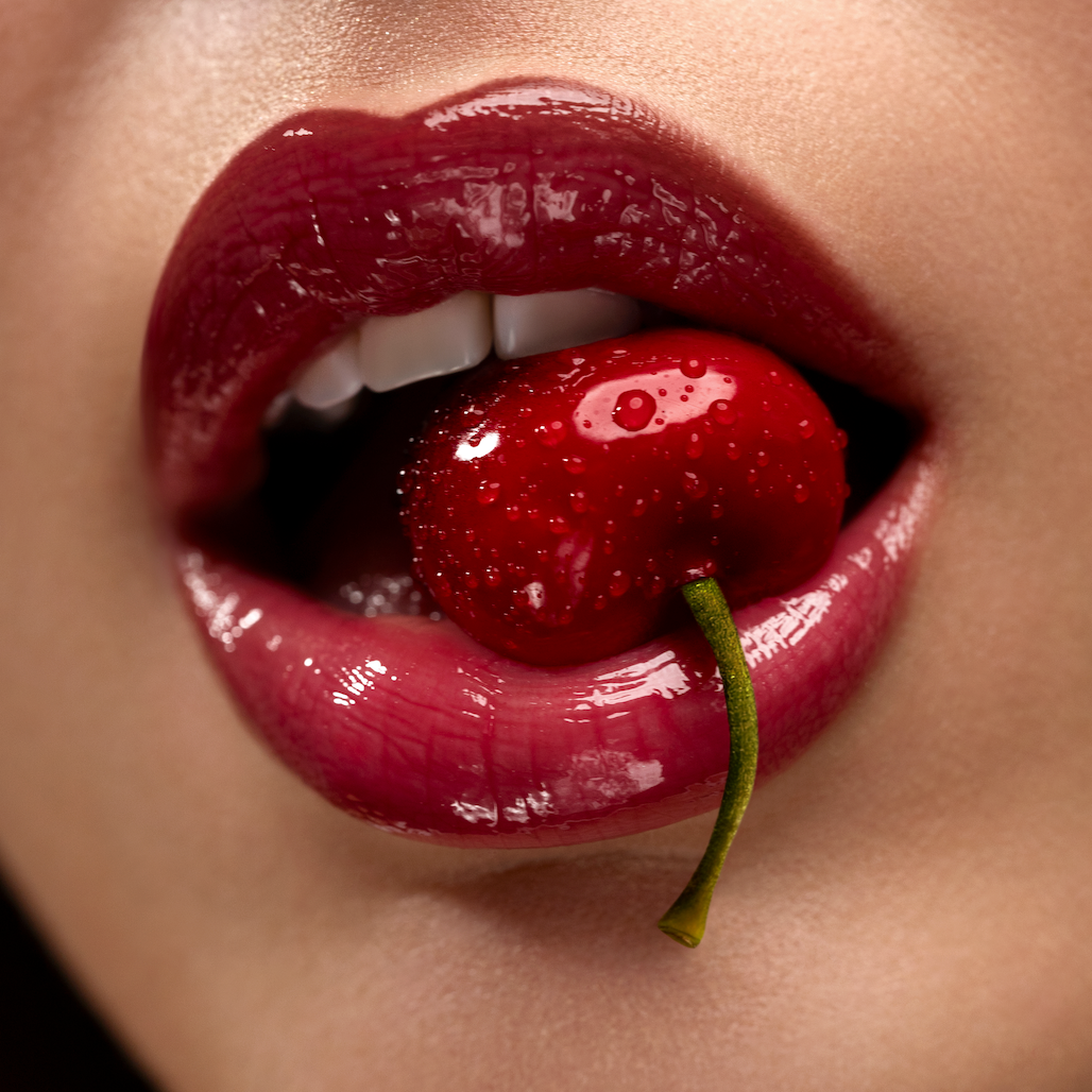 Close-up of a person's lips with a cherry