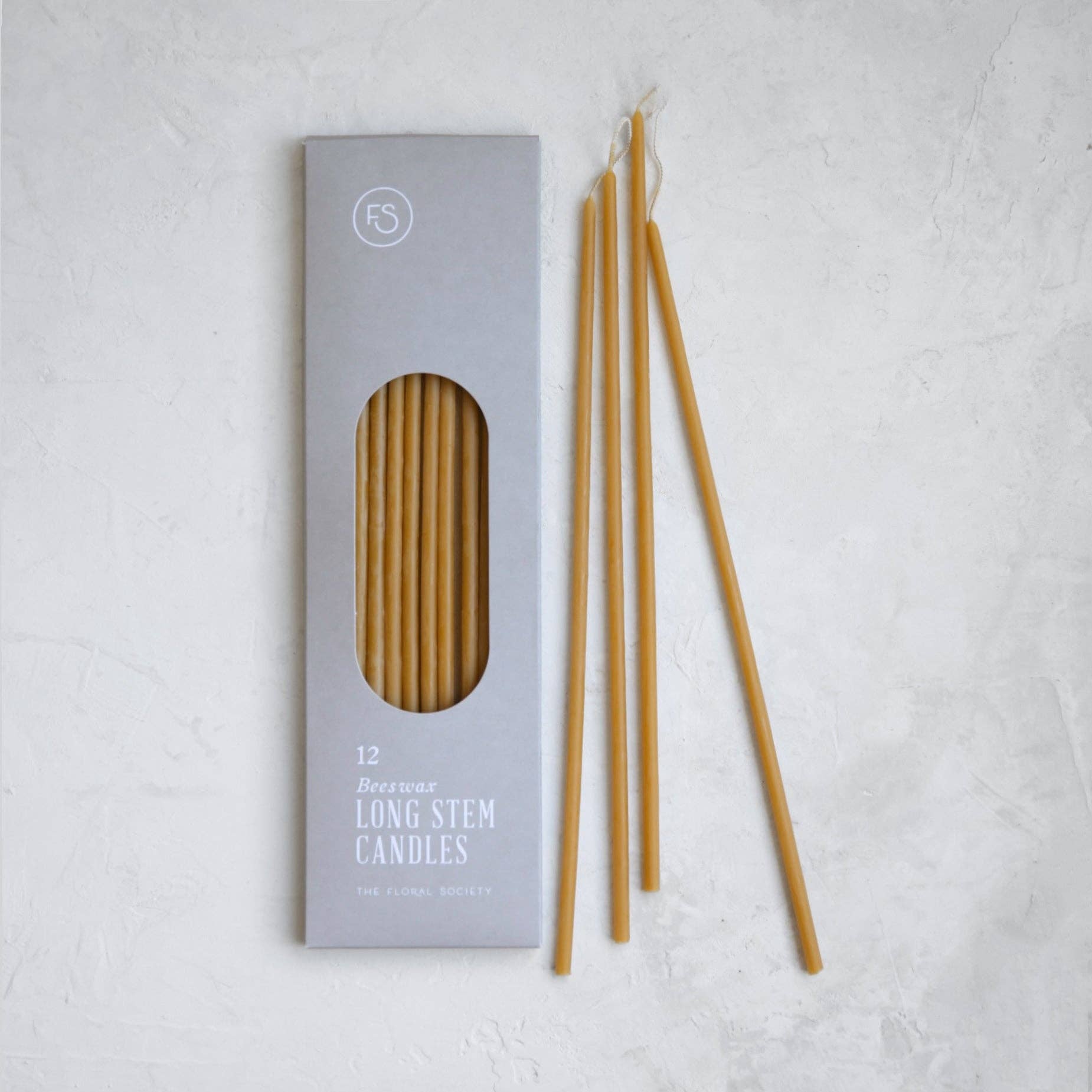 Set of long stem candles with packaging on a light gray background