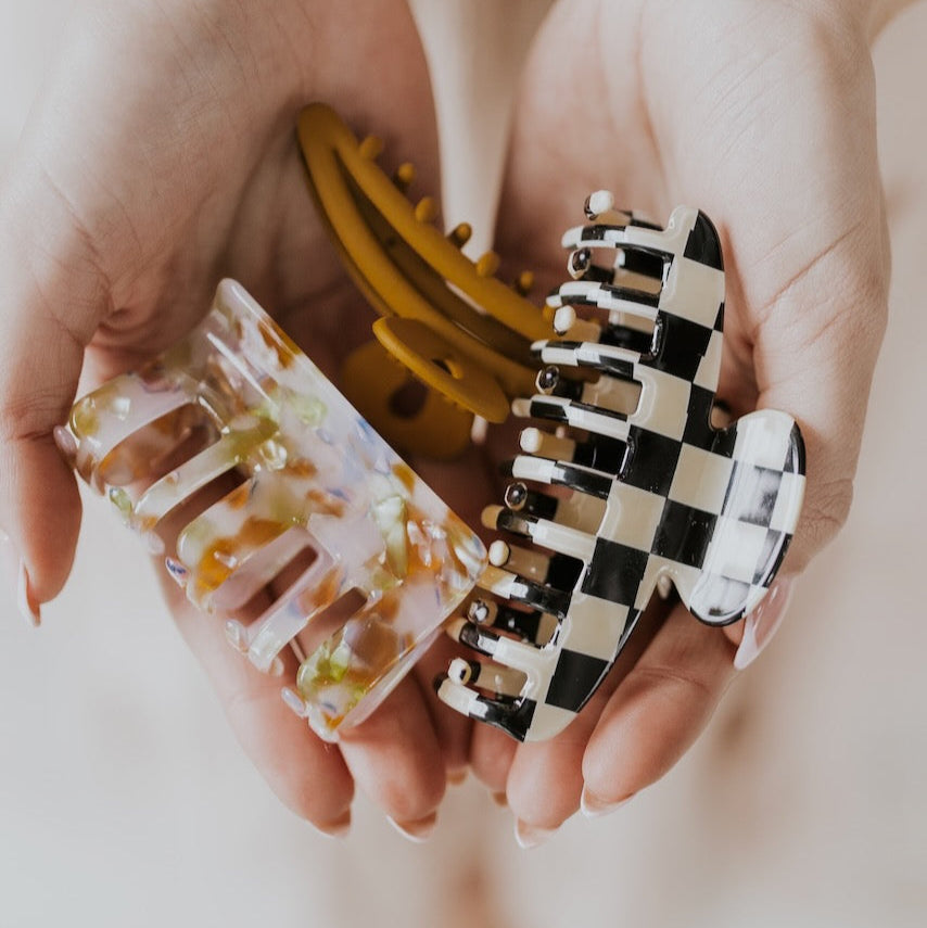 Step back in time + accessorize in style! These retro and funky claw clips come in a pack of three with one checkerboard, one solid tan + one multicolor clip. I don't know about you but I will be wearing these on repeat all year long!