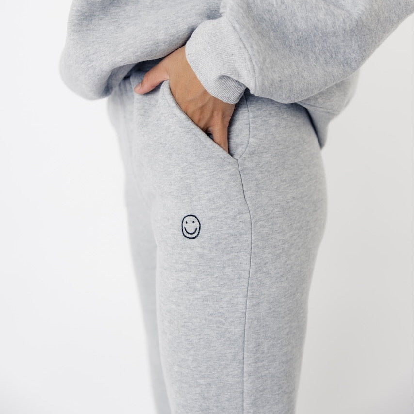 We got nothing but smiles here at ROOLEE :) These soft, french terry sweatpants feature an embroidered smiley face graphic, elastic waistband, + working pockets. 
