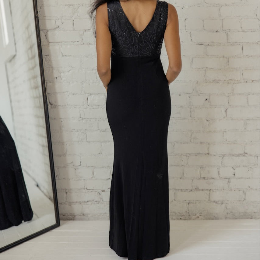 A world class choice when in evening wear, the Gala Timeless Sequin Detail Dress is a needed addition to any woman's formalwear repertoire. With a stunning v-neck pathing a way to a lace + sequin bodice, this dress will take any breathe away. This timeless piece also exhibits a slim silhouette created by back and front darts, a flirty leg slit, and a hidden back zipper. So, what gala are you attending tonight?