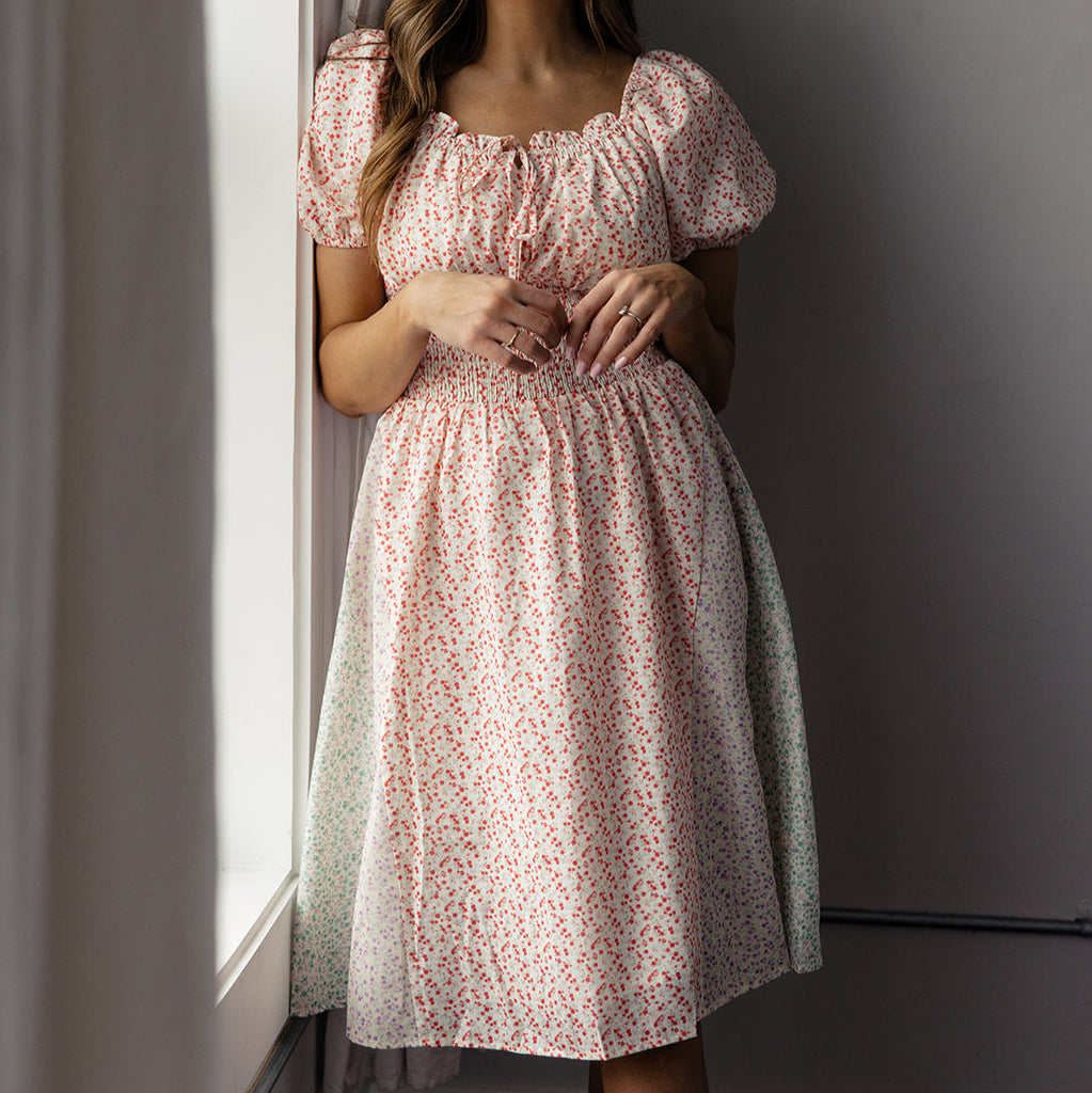 This women's dress features the same dainty florals, puff sleeves, and a charming tie neckline as the kids' version, creating a harmonious and stylish look. The patchwork details on the skirt add a playful and whimsical touch. Embrace the joy of twinning with your little one and make a fashion statement with the Sunday Morning Detail Dress. Perfect for creating beautiful memories and unforgettable moments together. 