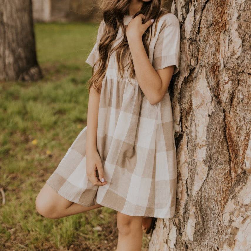 Now you and your mini can match in this ROOLEE classic! This dress features a timeless buffalo plaid that is bold, sophisticated and the perfect style for every occasion. Breathable, woven material is paired with hip pockets, half sleeves, a full lining, a gathered waist, and a flowing skirt. The Mini Maddie Buffalo Plaid Dress is adorable, versatile, and sure to be your daughter's favorite dress! Tan Plaid