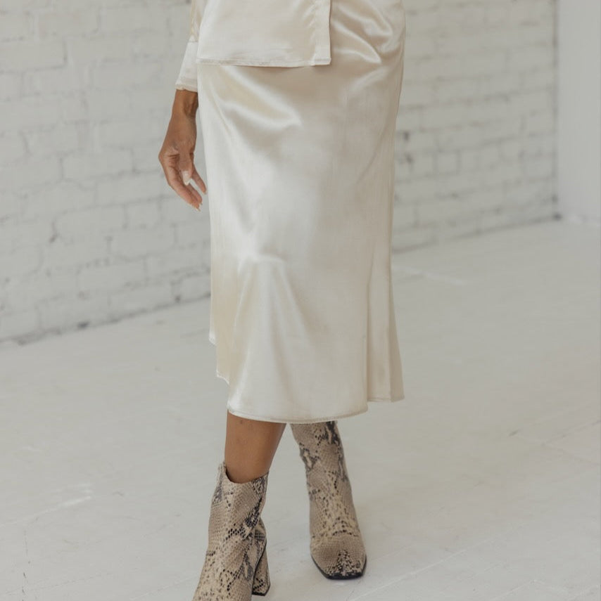 This skirt is made from strength and stardust. Drape this flattering and classic slip skirt on and you'll be ready for anything. Featuring an elastic waist, side zipper, and silky material. 