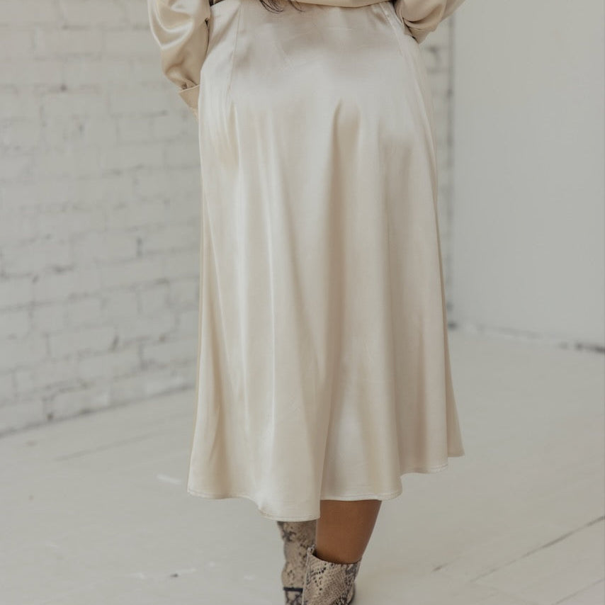 This skirt is made from strength and stardust. Drape this flattering and classic slip skirt on and you'll be ready for anything. Featuring an elastic waist, side zipper, and silky material.